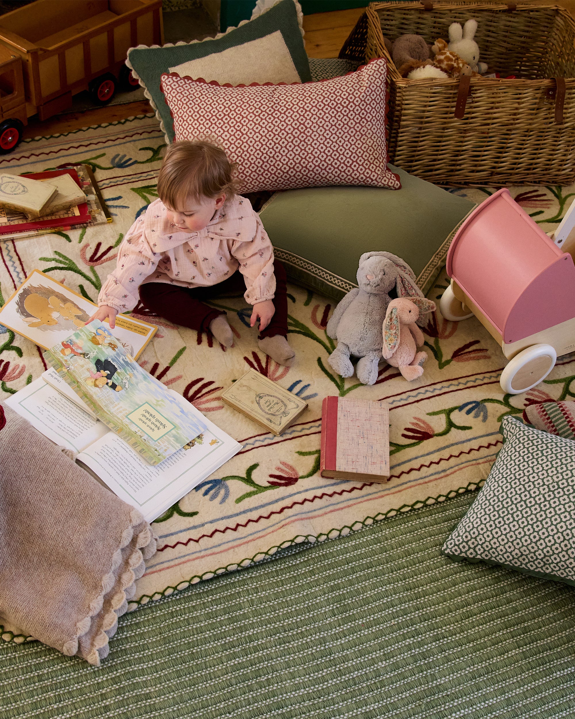 Child playing with toys on a colourful rug in a home setting