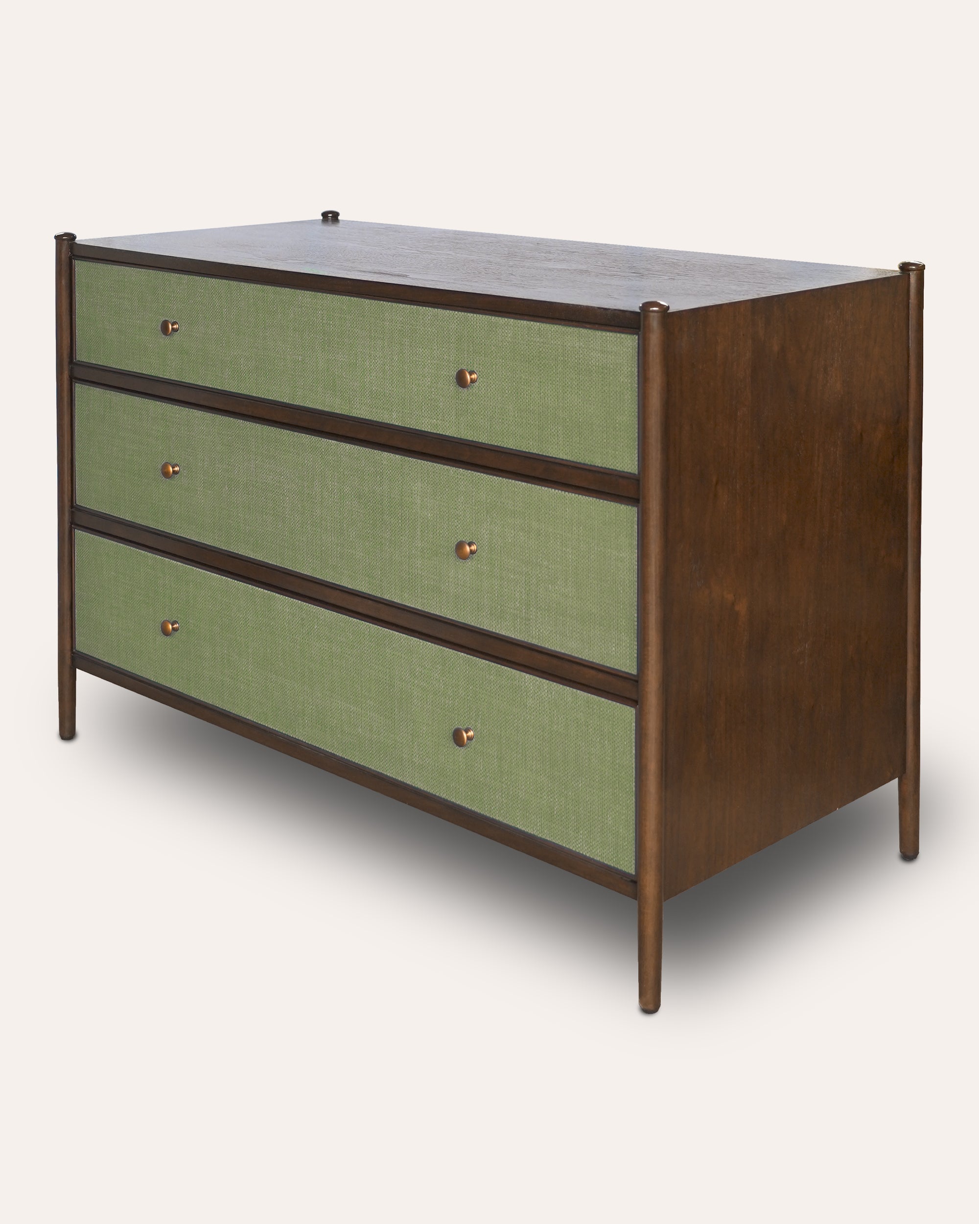 A mid-century modern three-drawer dresser with sage green linen drawer fronts, a dark brown wood frame, and small round brass pulls, shown on a light beige background.