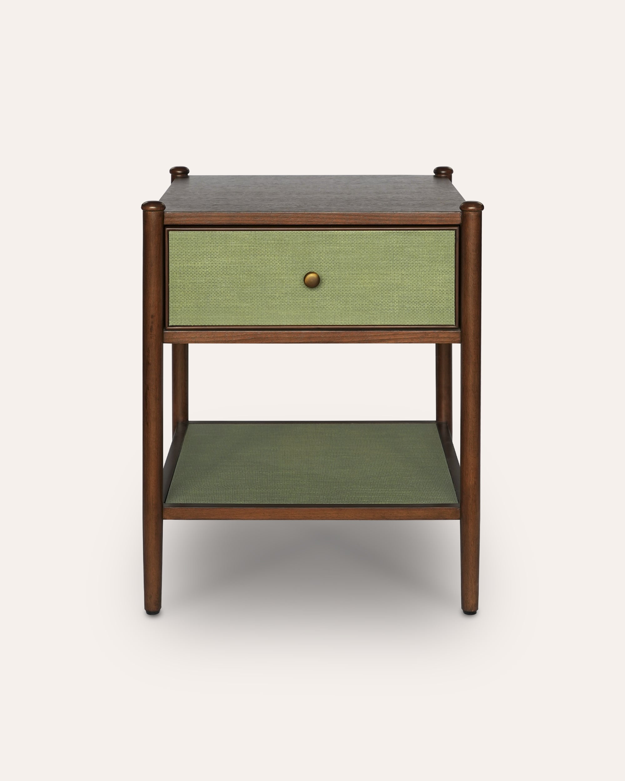 A mid-century modern side table featuring a dark brown wood frame, a light green woven drawer front with a single brass knob, and a matching green woven shelf below.