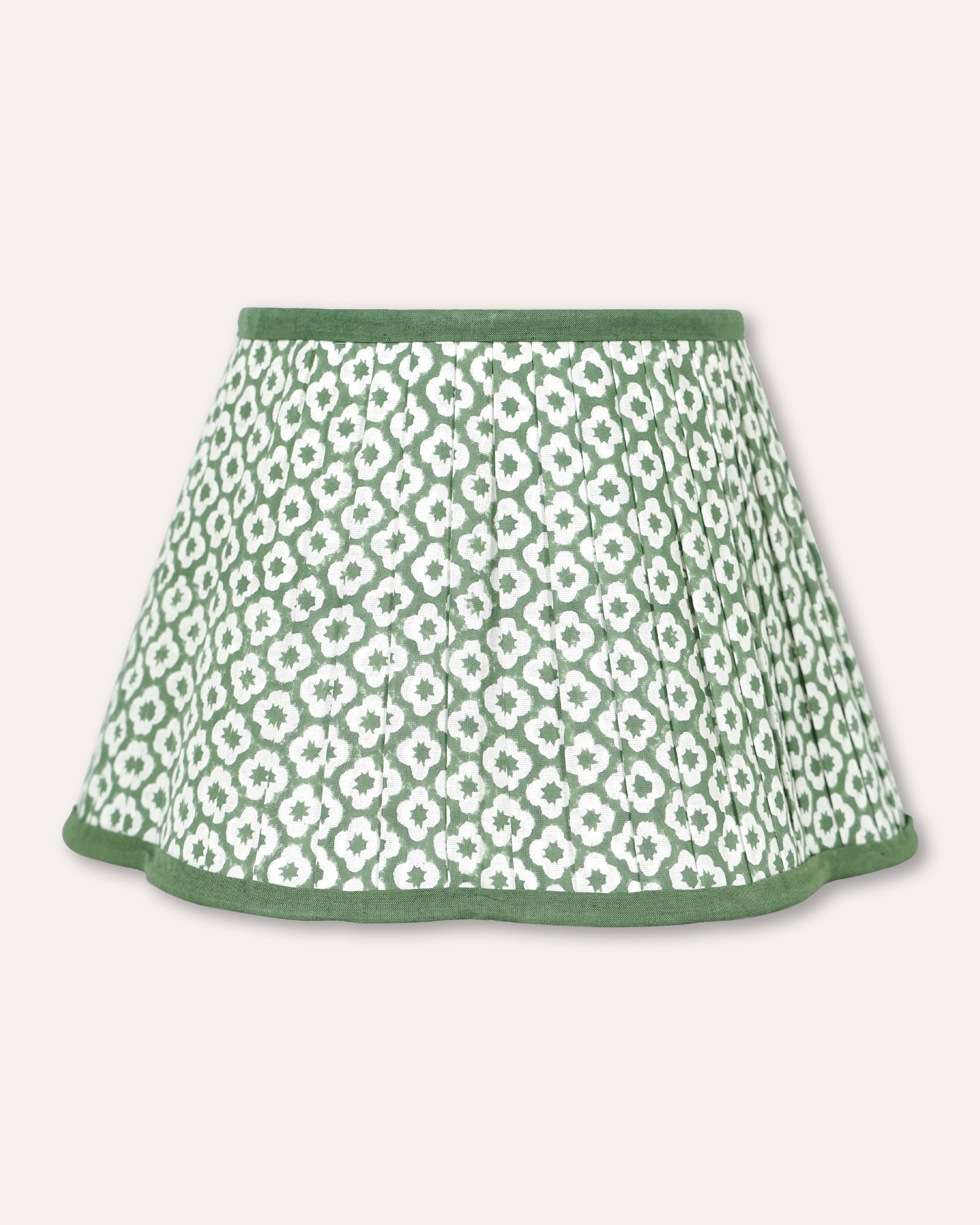 A green and white patterned pleated lampshade with a solid green hem, shown against a light beige background.