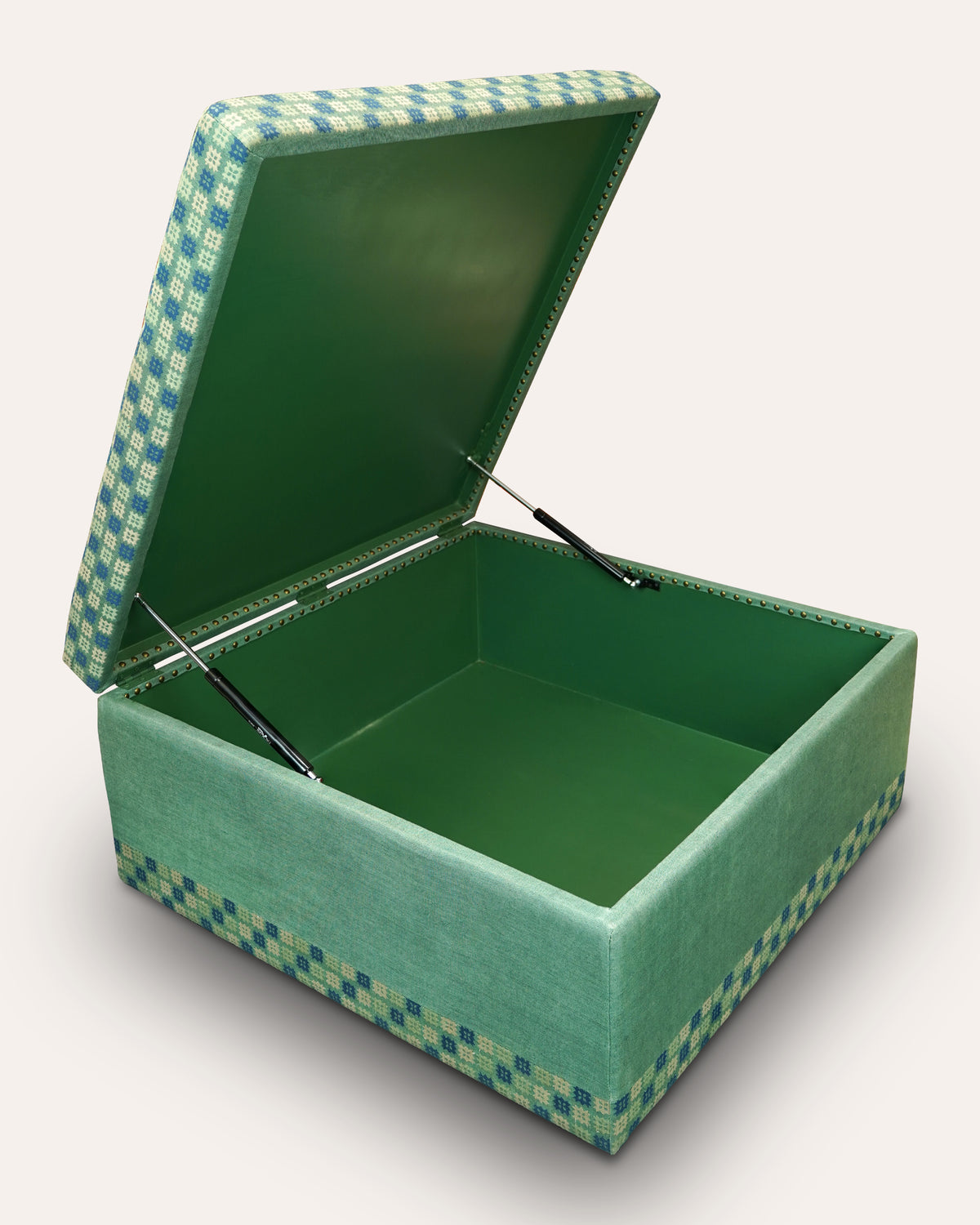 An open square storage box with a green velvet interior and lid, featuring a green and blue checkered patterned fabric exterior and side trim, supported by two metal gas struts against a light beige background.