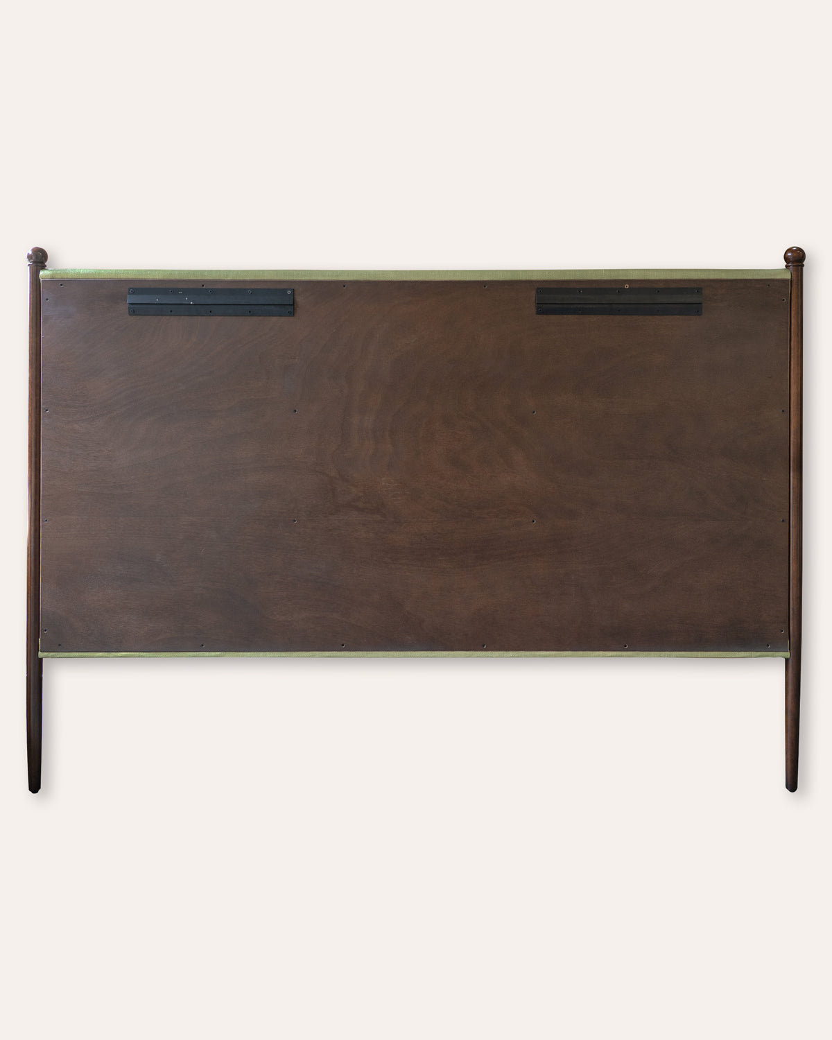 A dark brown wooden headboard with a natural wood grain finish, featuring two black rectangular metal mounts near the top and a light green top rail, shown against a plain off-white background.