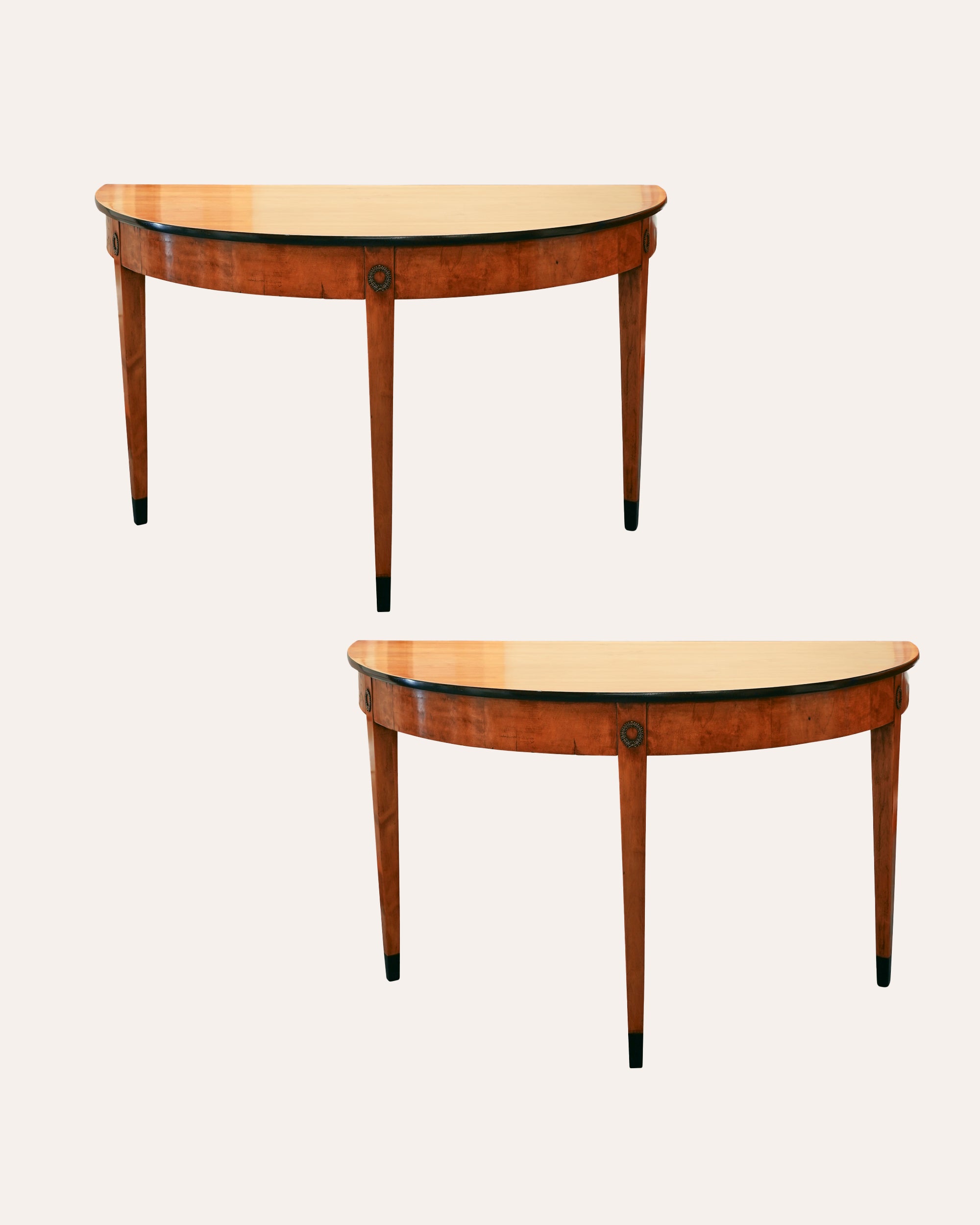 Two identical half-moon wooden tables with a light-colored top on a white background