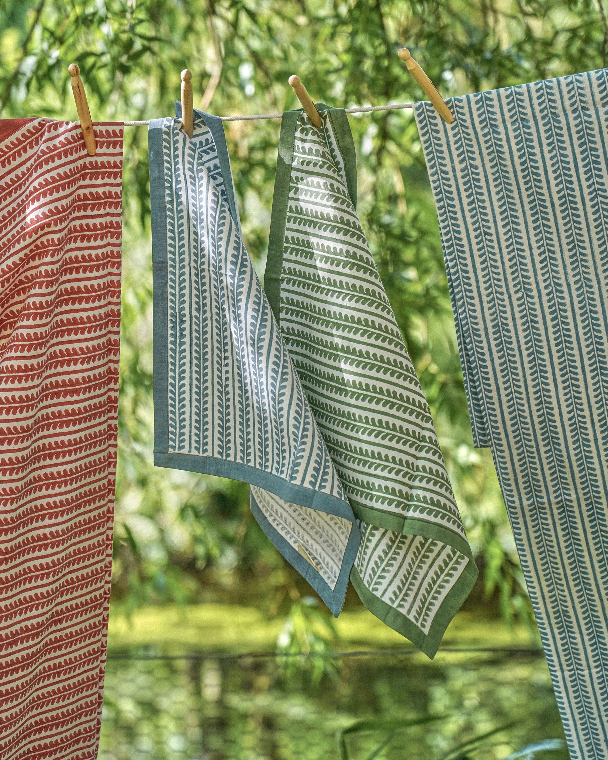 Patterned napkins hanging on a clothesline with a natural background