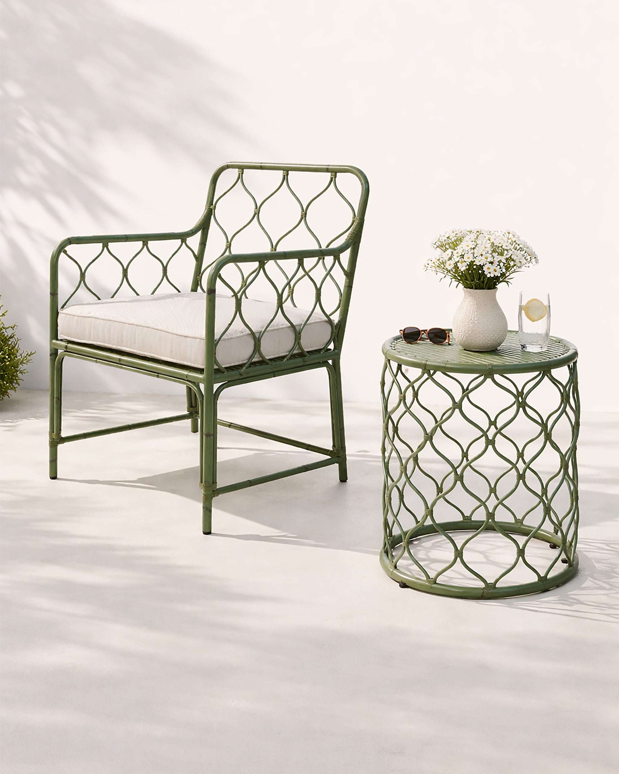 Green metal armchair and side table with white cushion on a white background