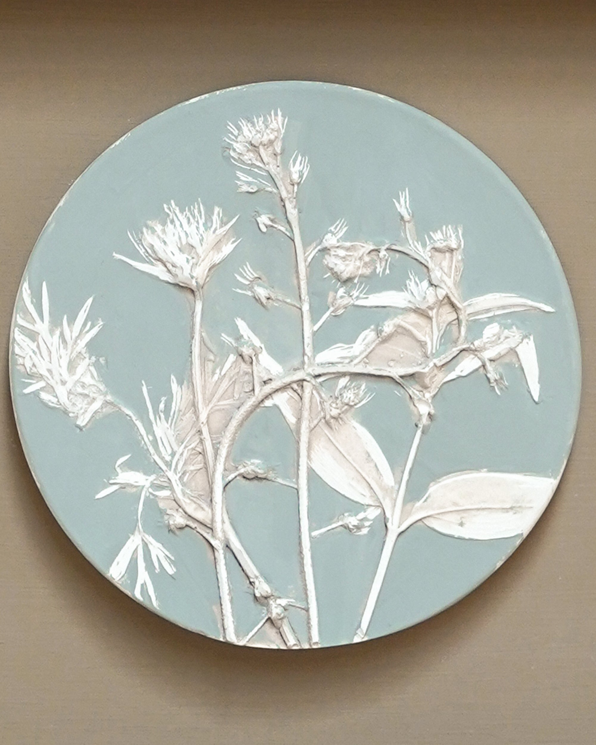 Round decorative cast with white floral design on a light blue background