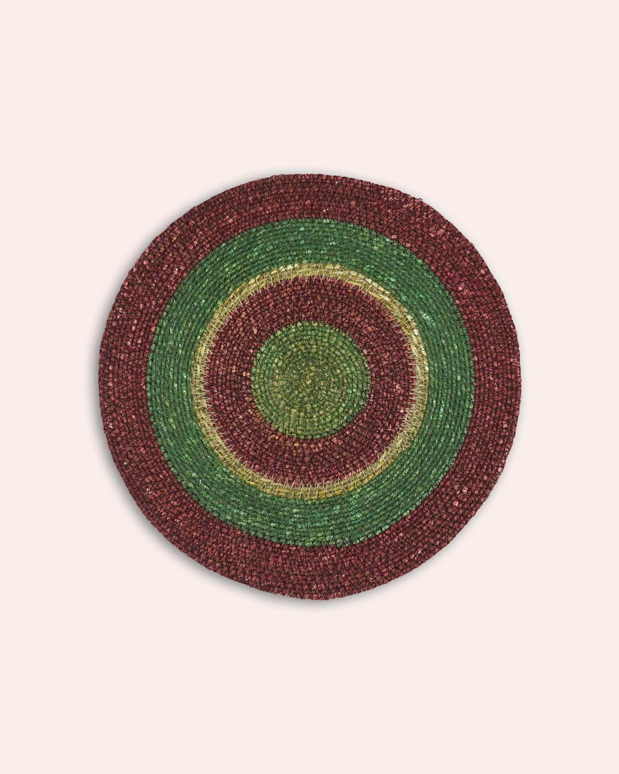 Round woven placemat with concentric circle pattern on a beige background