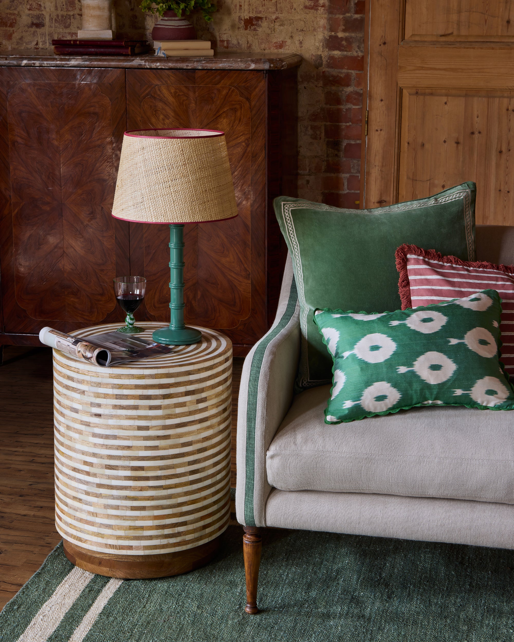 Gloss Painted Wooden Column Table Lamp with Seema Raffia Lampshade - Hedge Green, in a red and green sitting room