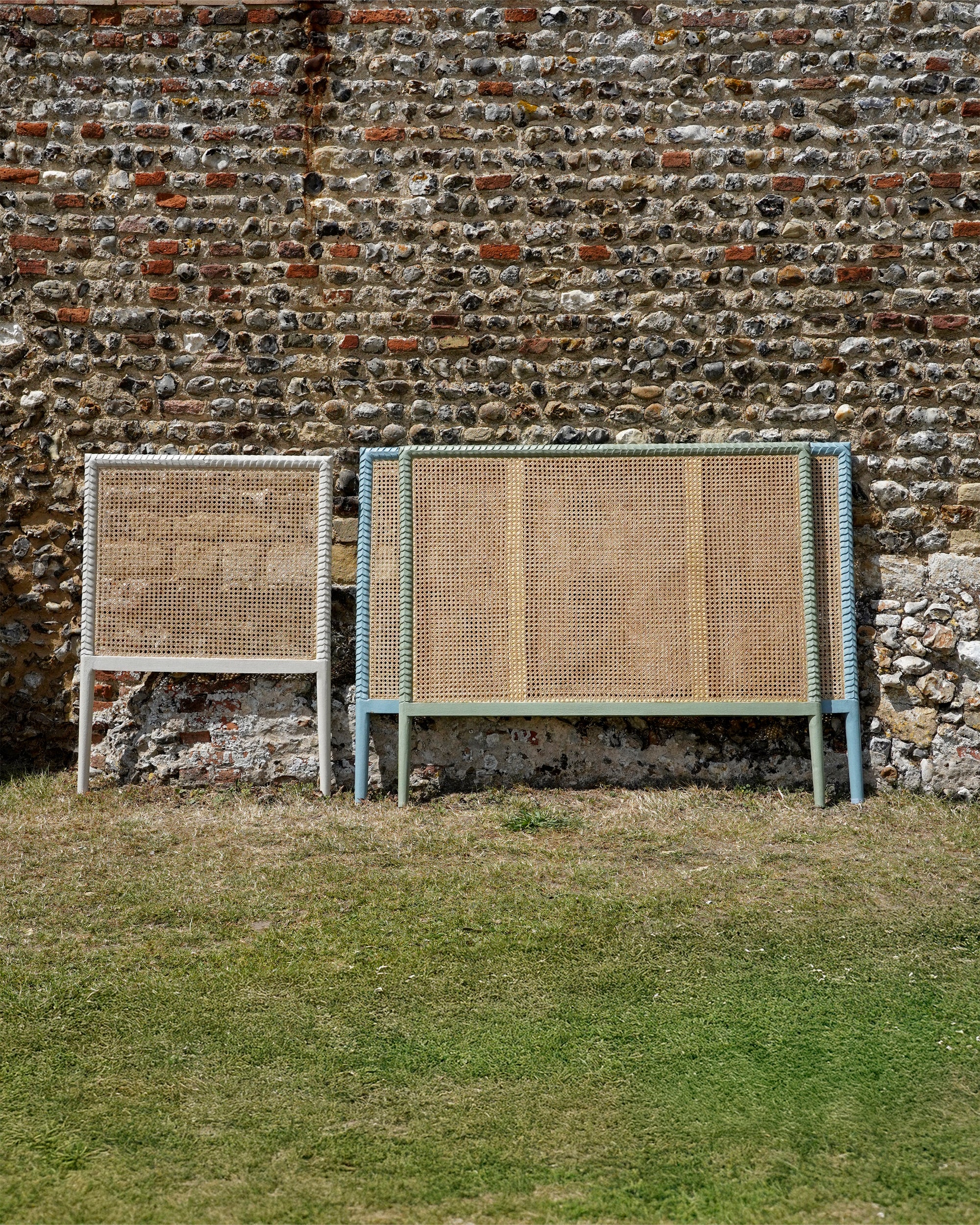 Rattan headboards against a stone wall.