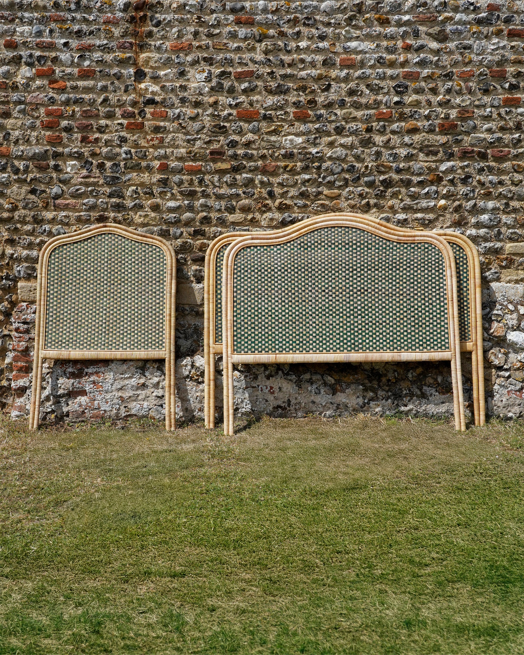 Rattan Headboards leaning against brick wall outside