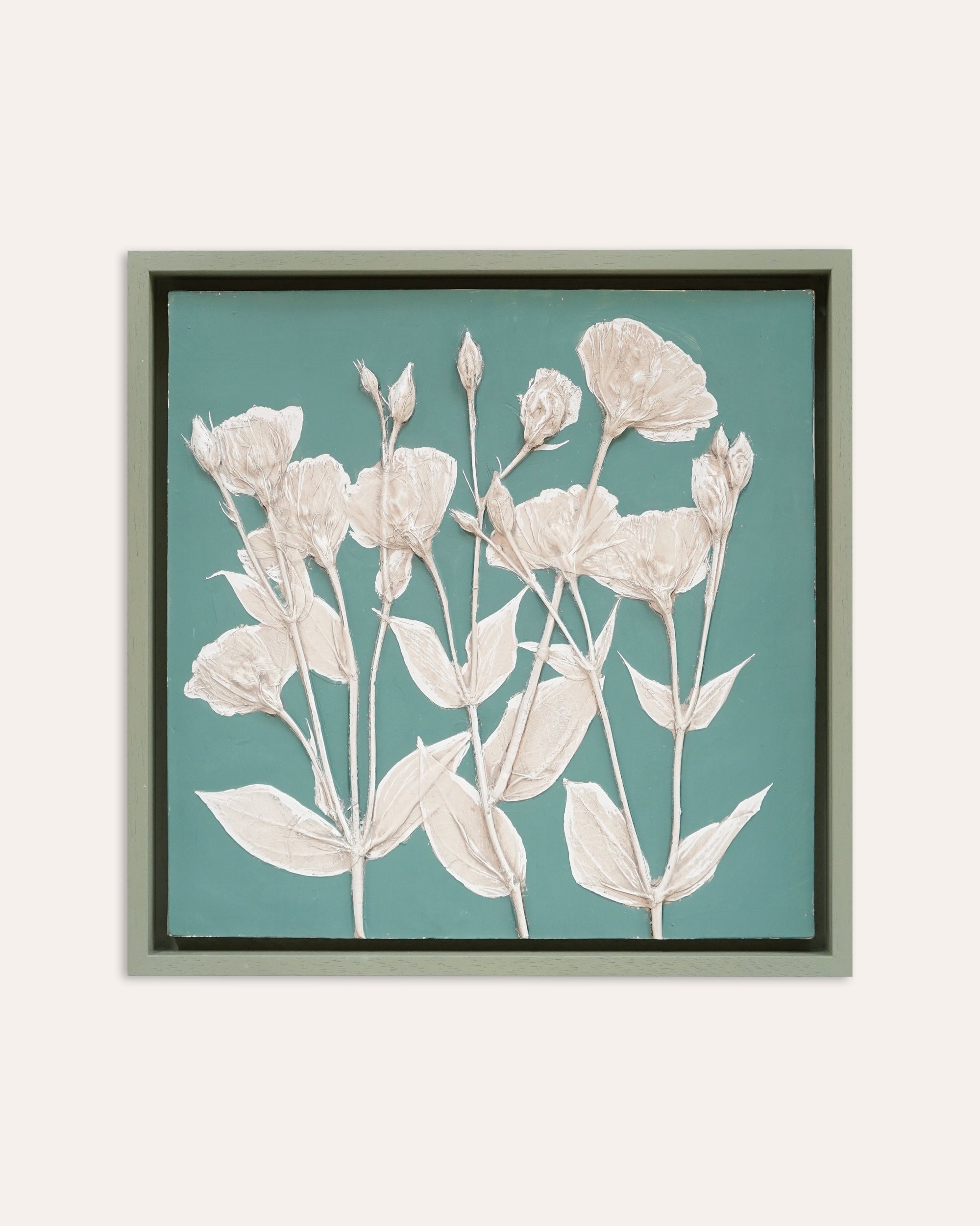 Framed artwork of floral design on a teal background