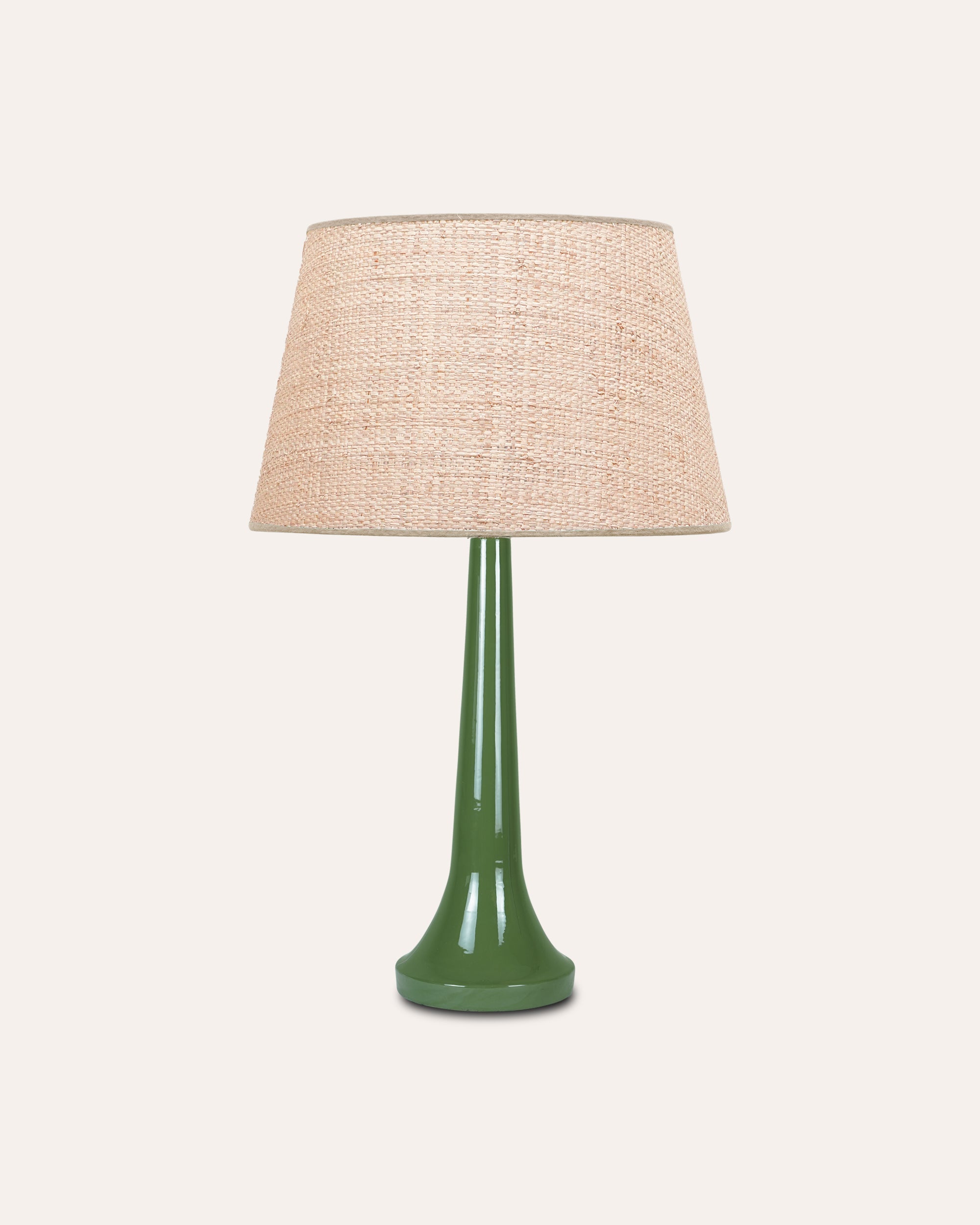 Table lamp with a green base and beige lampshade on a white background