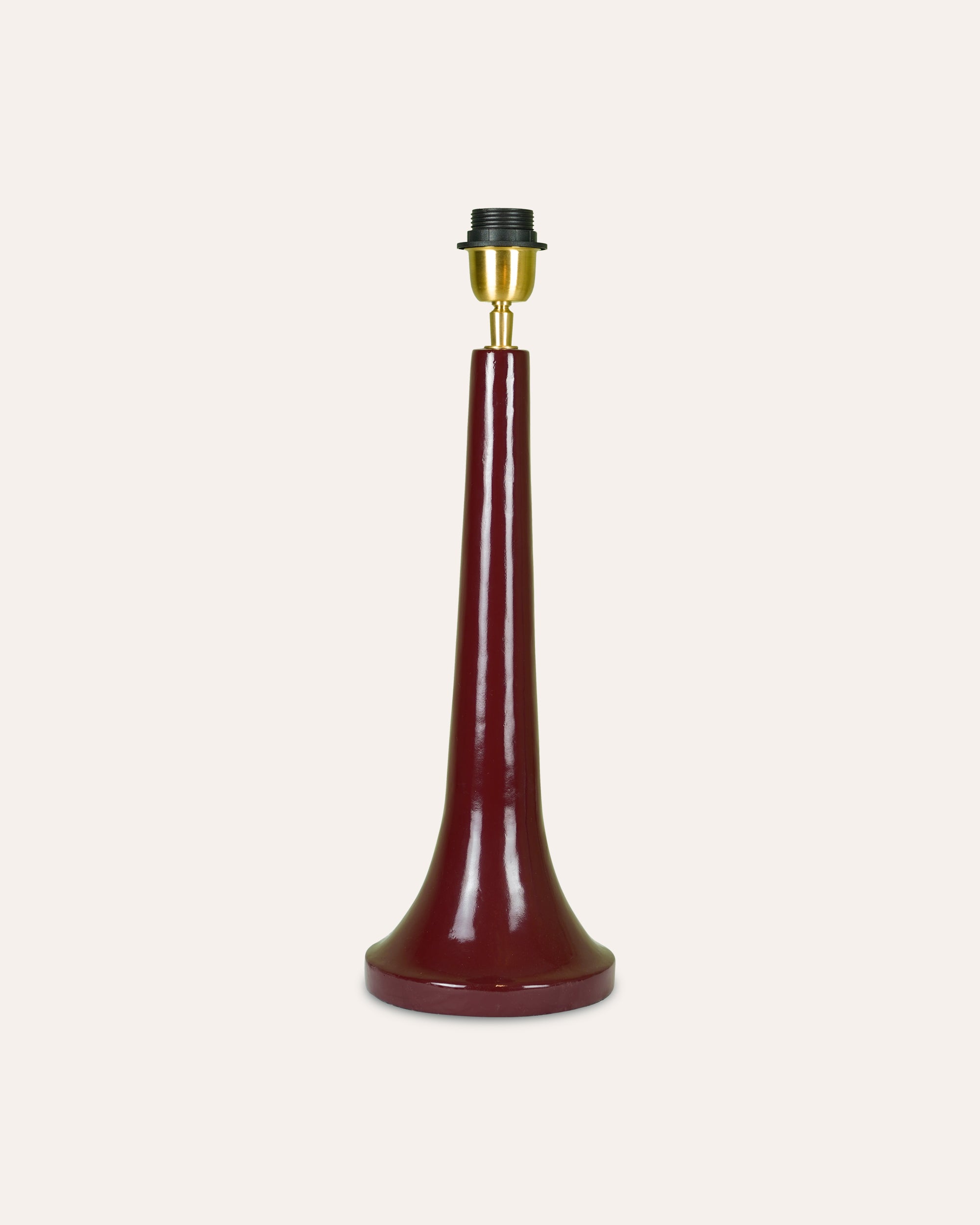 Red lamp base with brass fitting on a white background