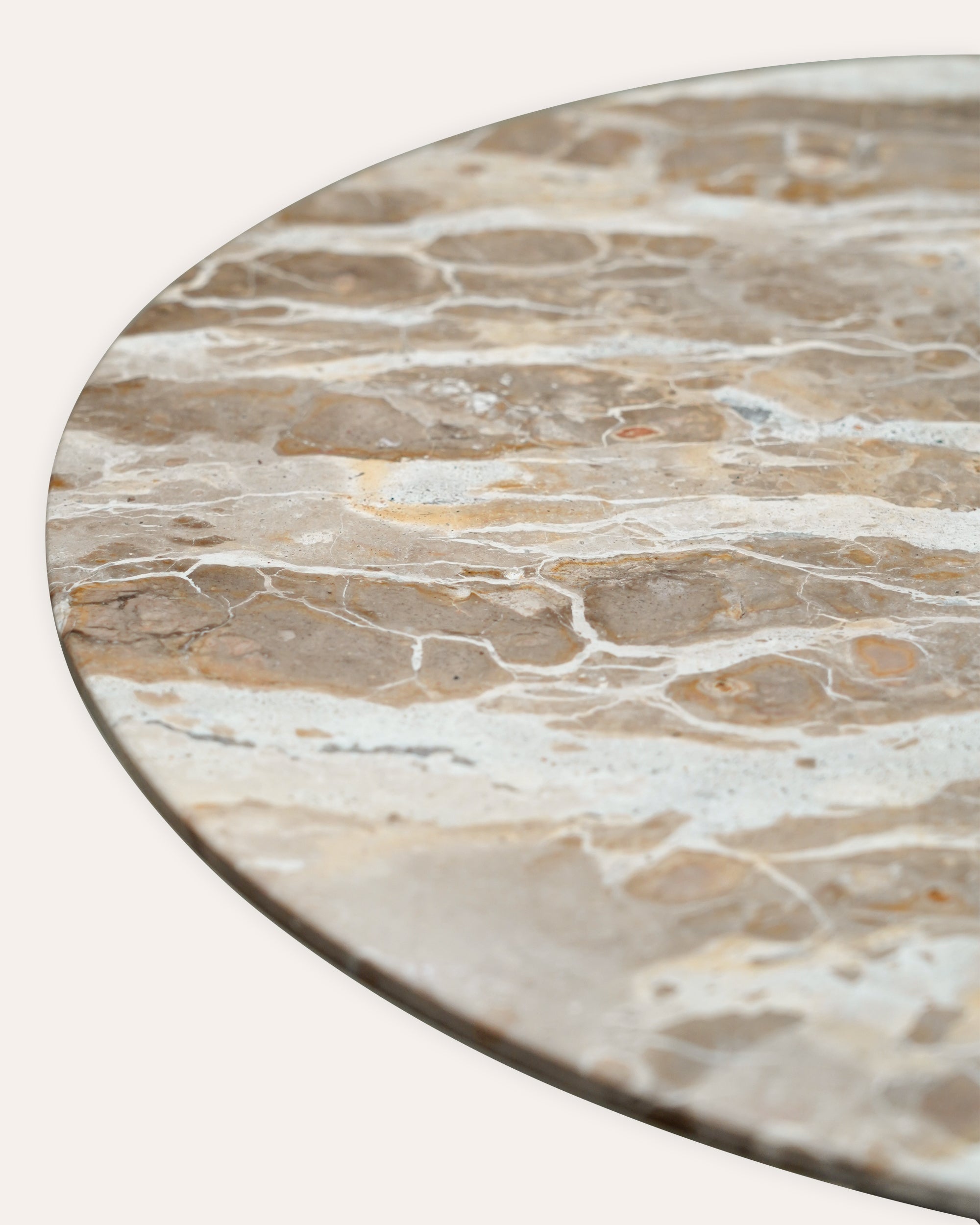 Round marble table top with beige and brown patterns on a white background