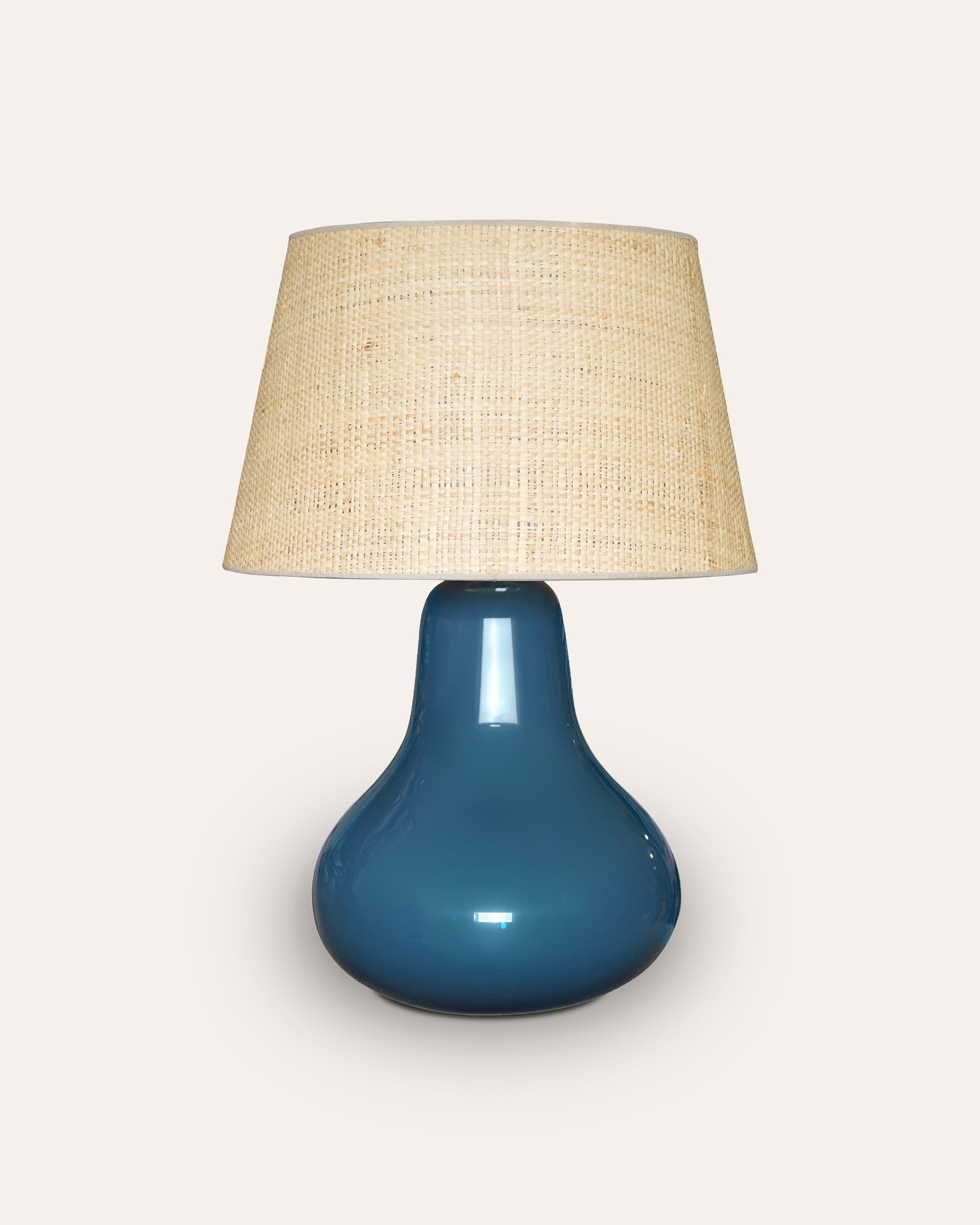 Blue Nashpati table lamp with a beige lampshade on a white background