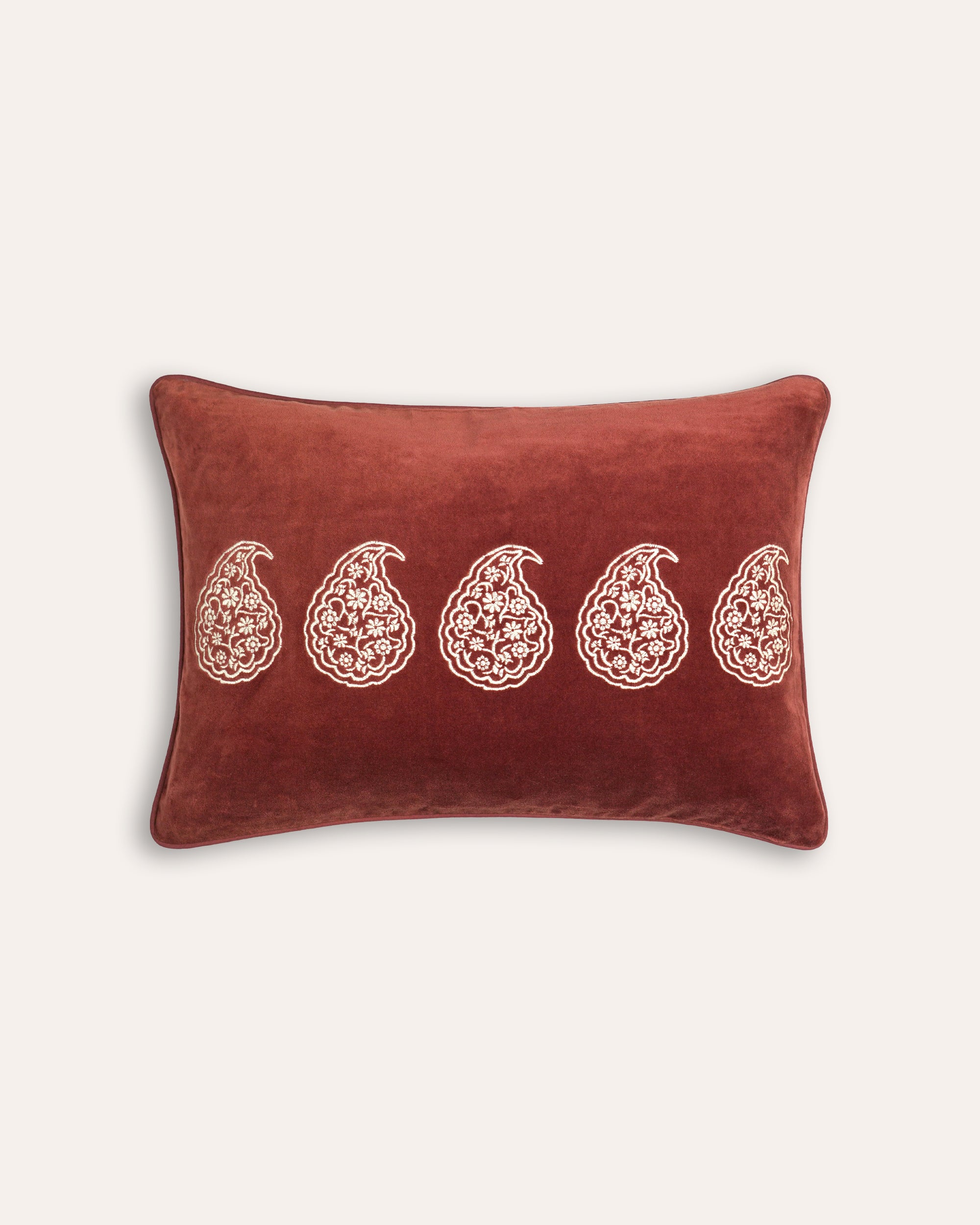 Red cushion with white floral patterns on a beige background