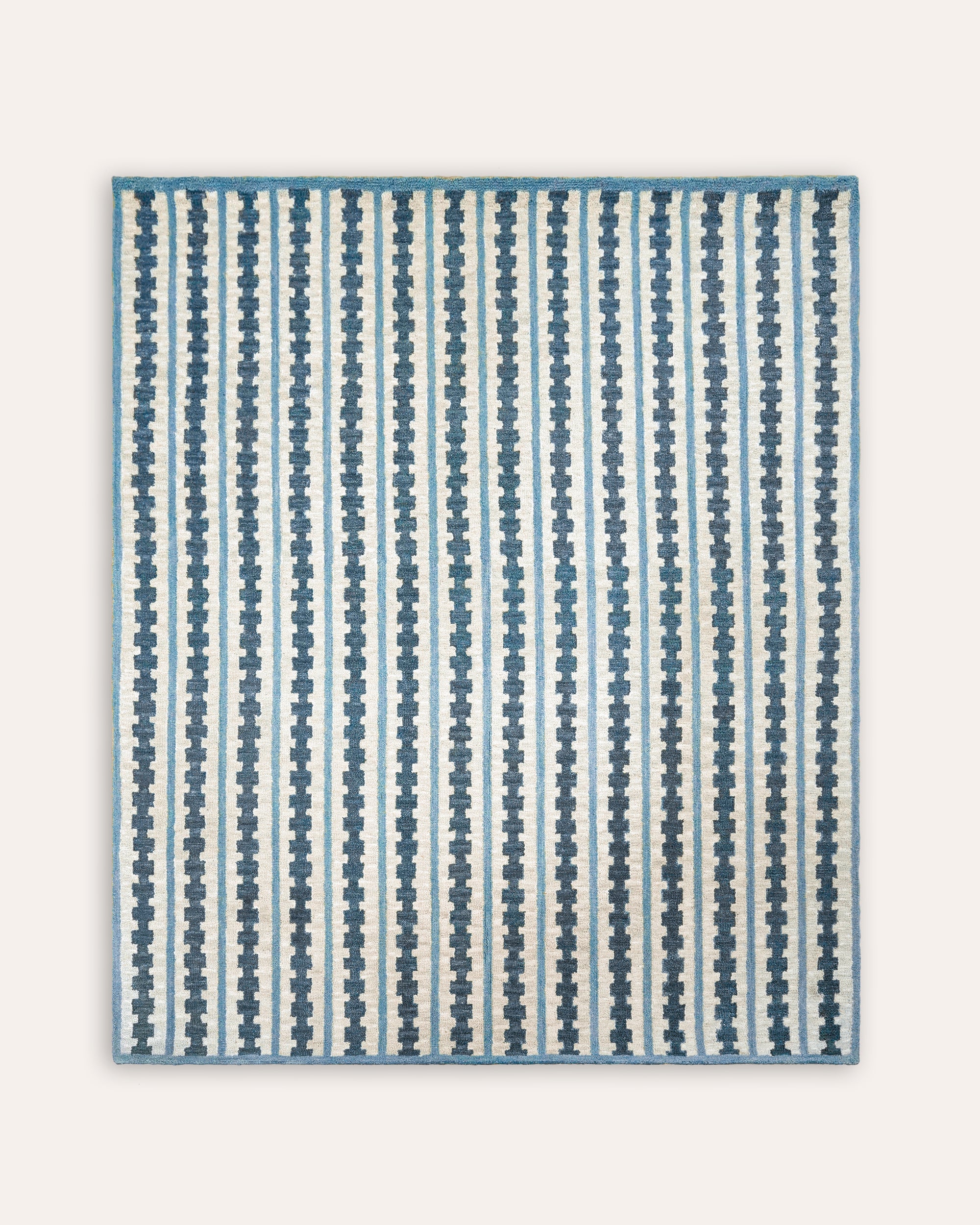 Striped blue and white rug on a light gray background