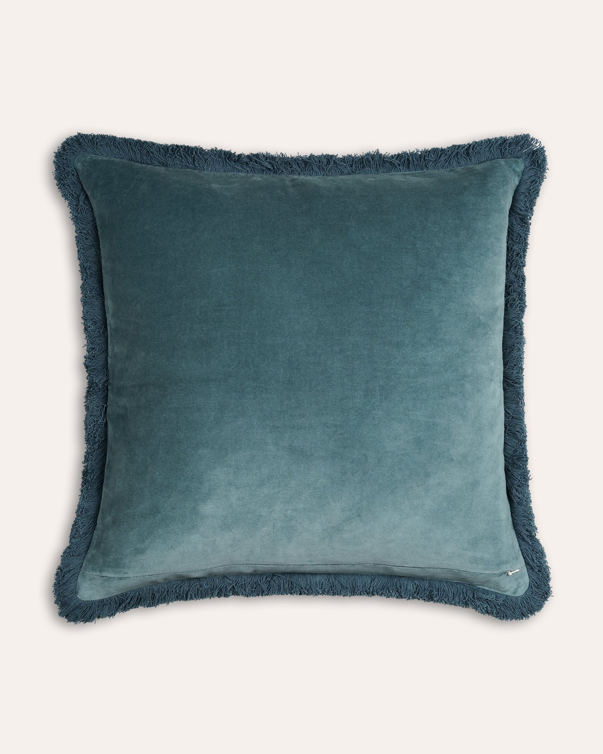 Teal cushion with frayed edges on a white background