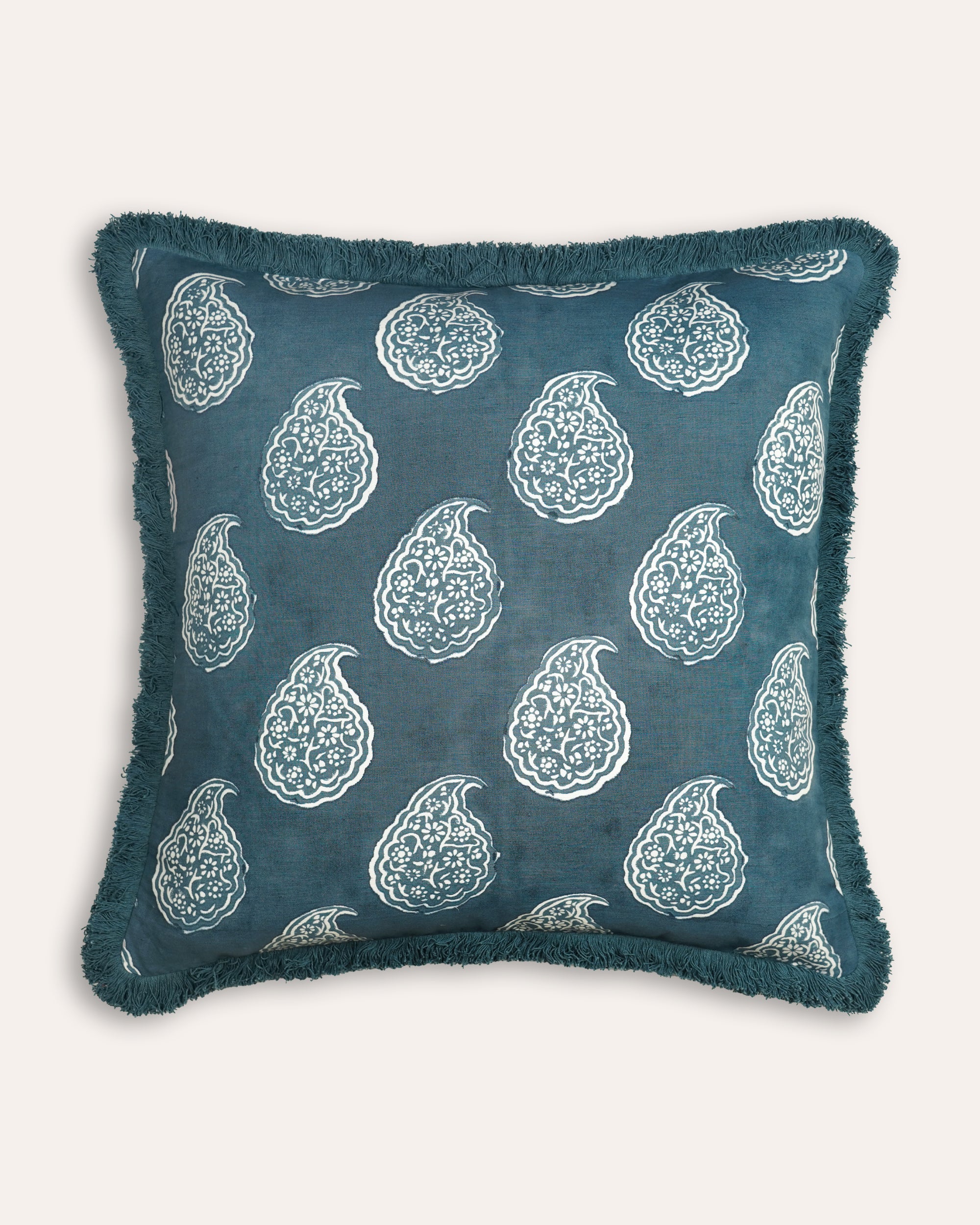 Blue cushion with white floral patterns on a white background