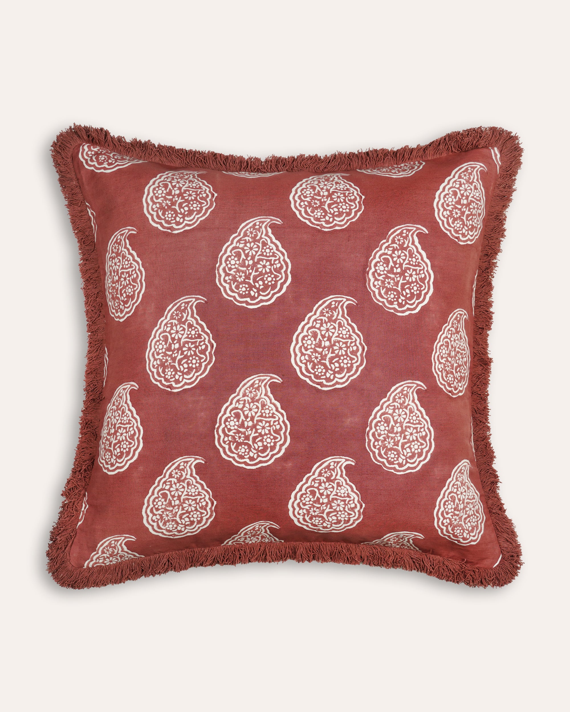 Red cushion with white paisley patterns on a white background