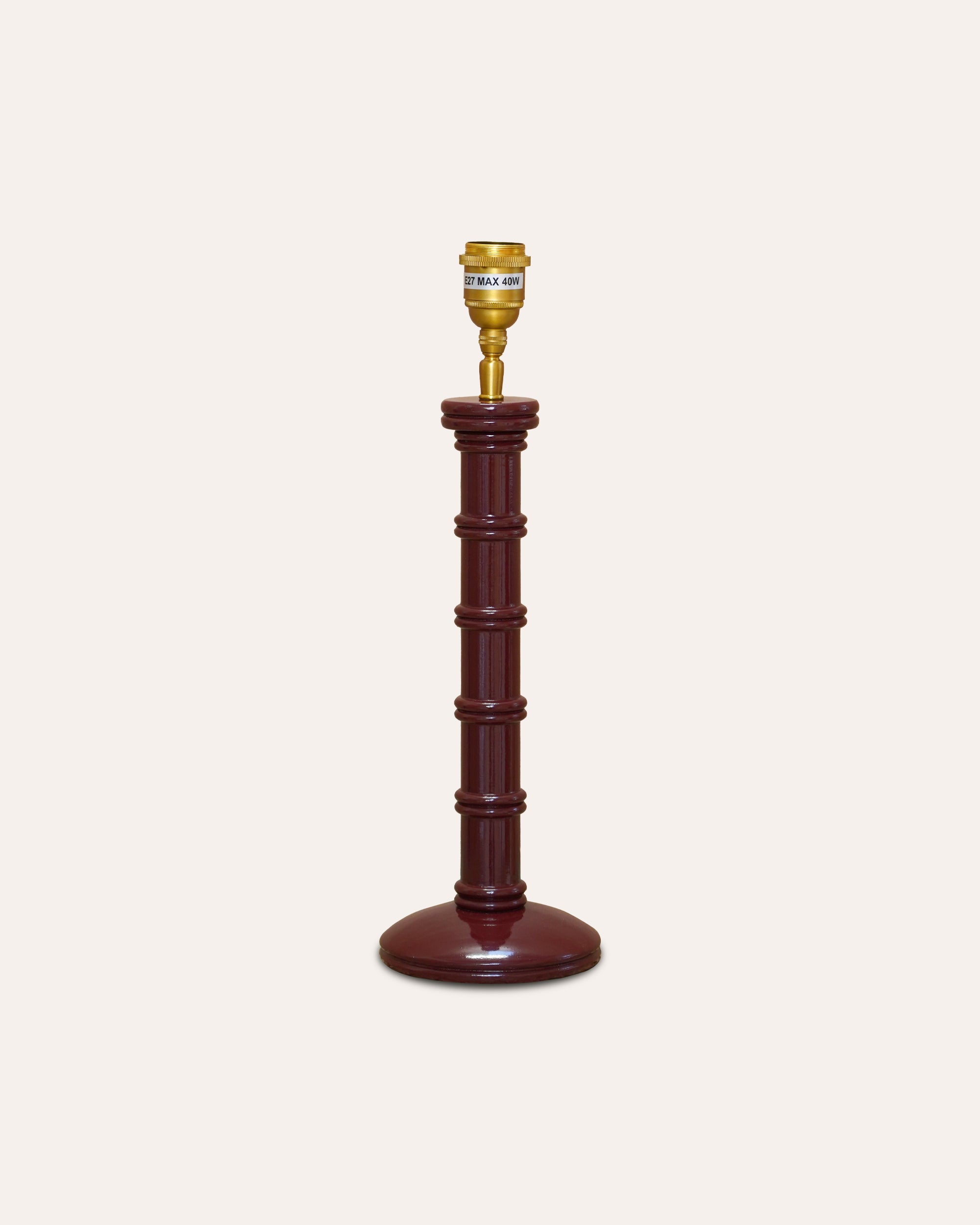 Decorative lamp with wooden base and gold top on a white background