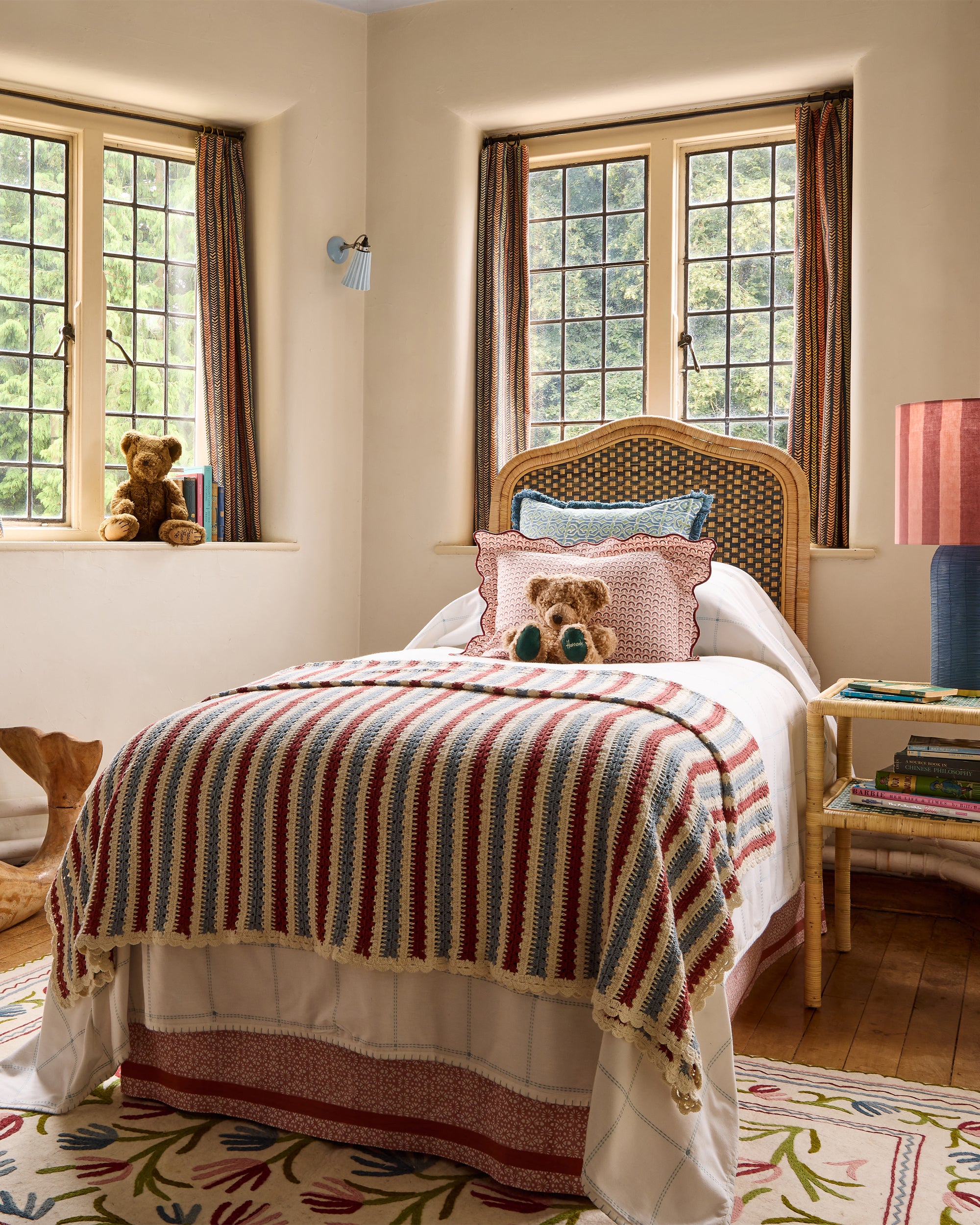 Children's bedroom featuring the single rattan blue headboard, Teja cushion, striped crochet throw and namda rug