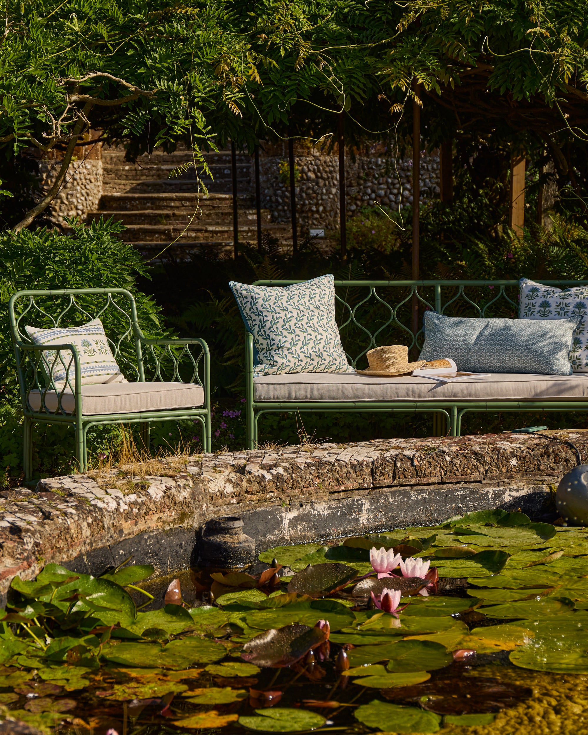 Outdoor spring summer seating showcasing the curato furniture and Birdie Fortescue's SS25 blue and green cushions