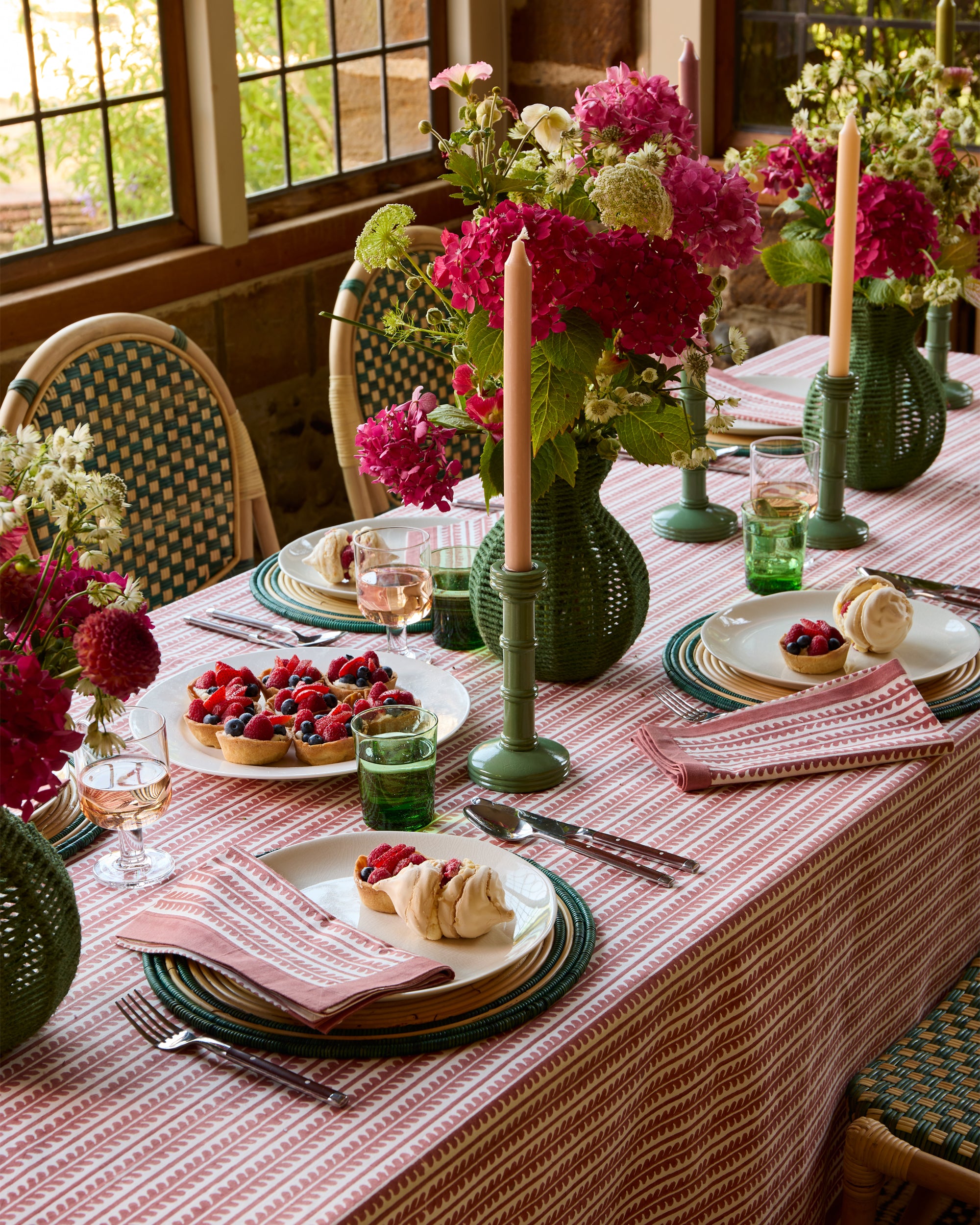 Pink and green spring summer tablescape, featuring the green column candlesticks, red bel tablecloth and green string vases