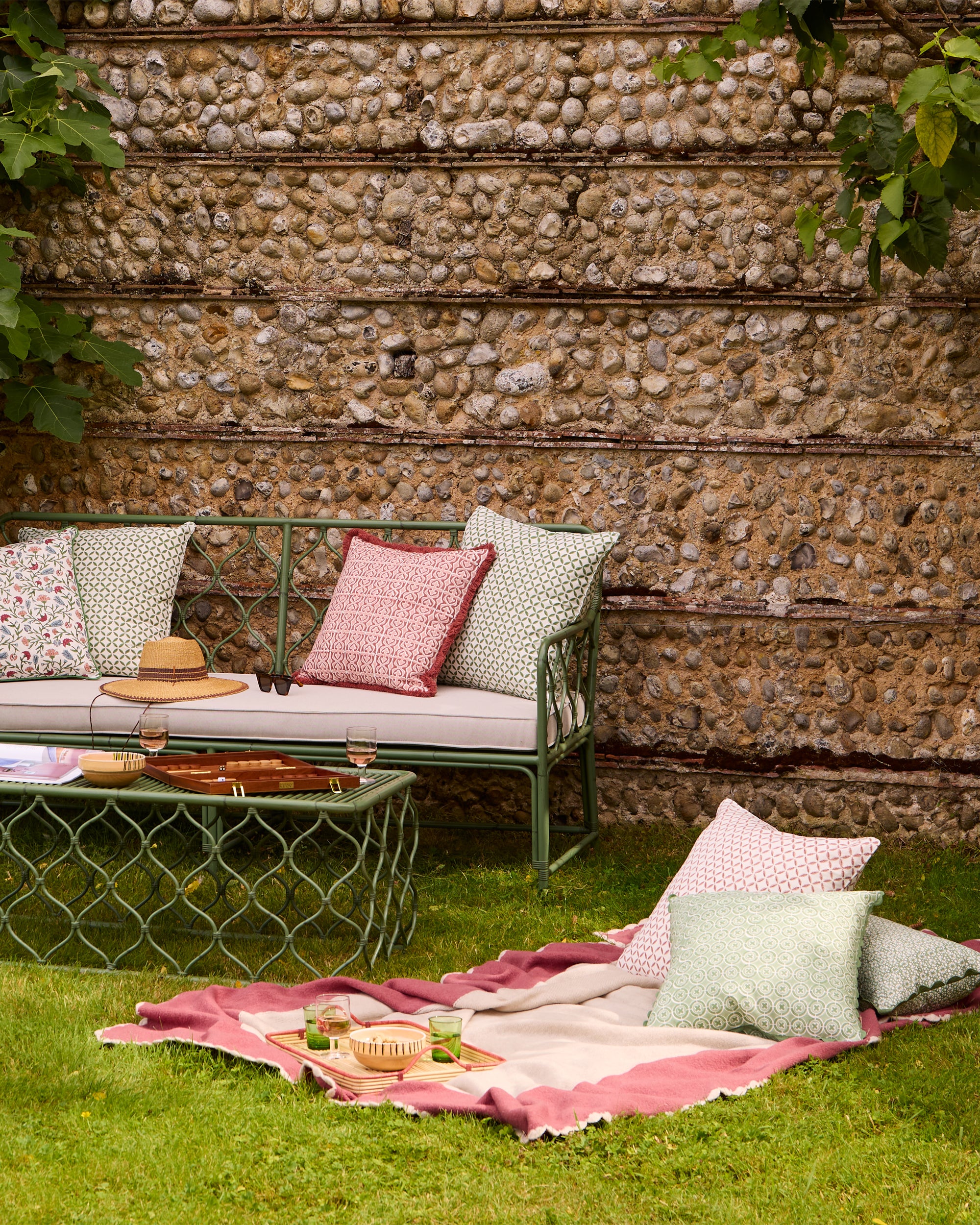 Summer outdoor garden lifestyle image, featuring pink and green soft furnishings and our Curato garden furniture