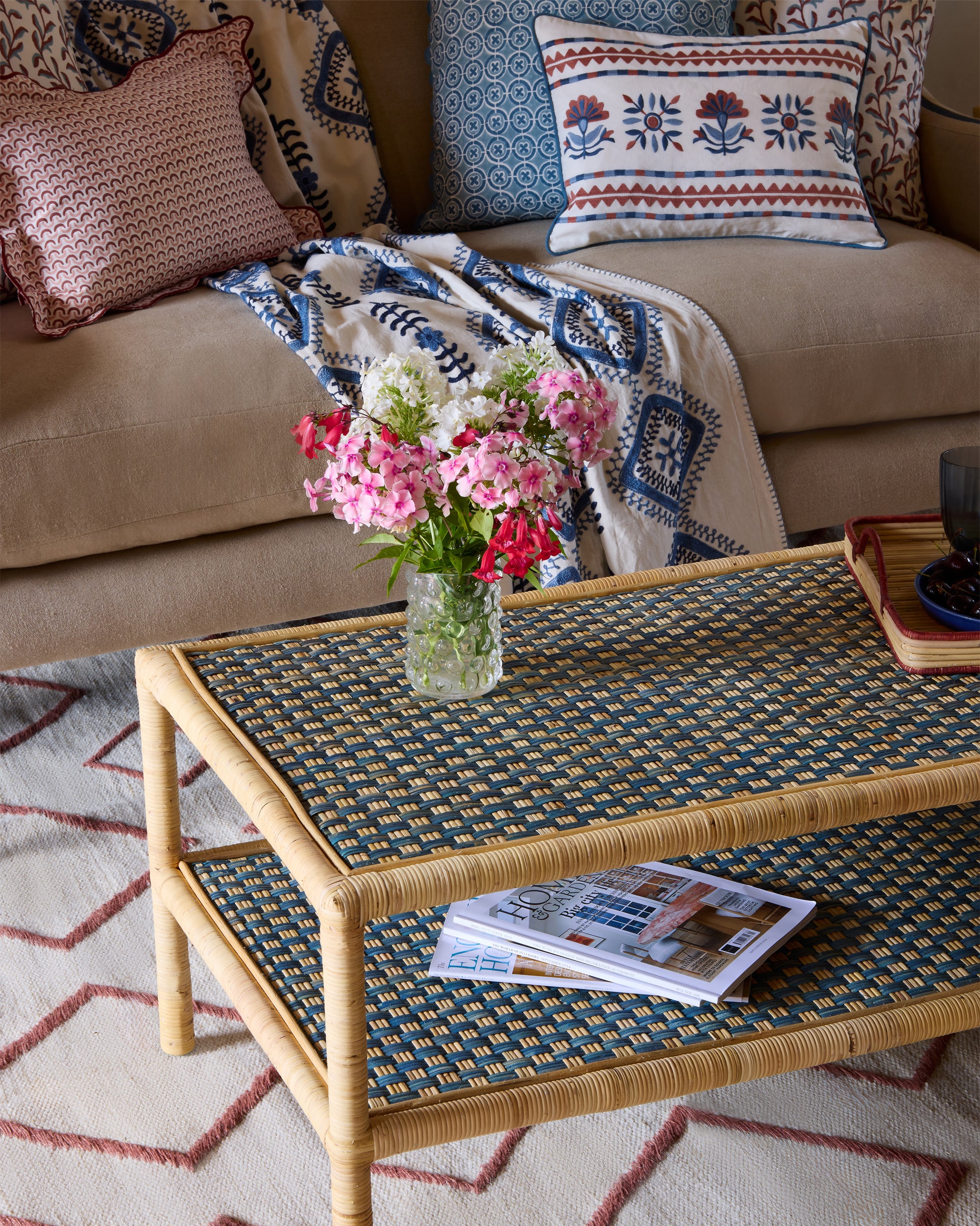 Close up detail image of the Rattan Ottoman in blue in a pink and blue sitting room setting