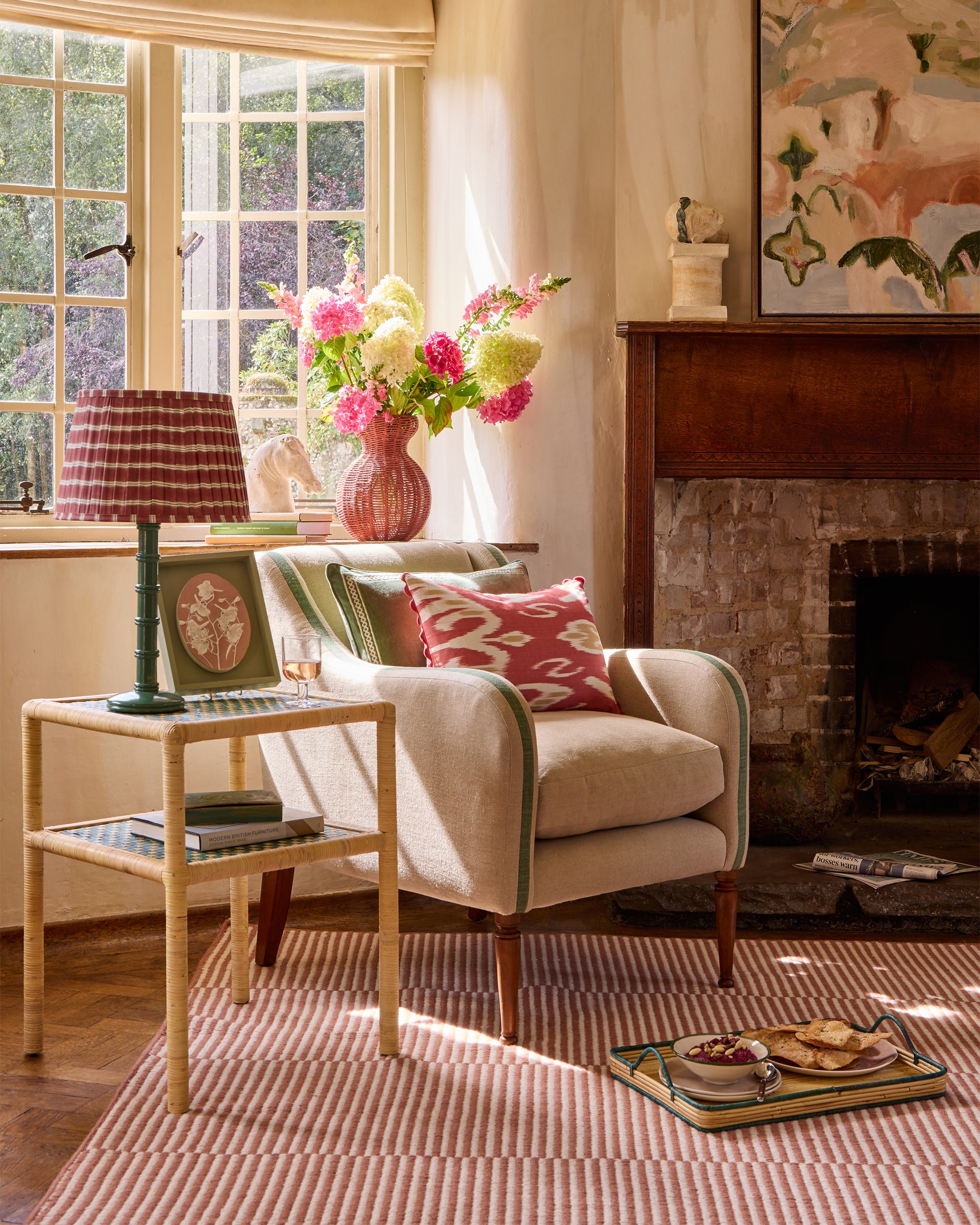 Pretty spring summer armchair lifestyle image featuring the green upholstered armchair, styled with the pink ikat red and gold cushion