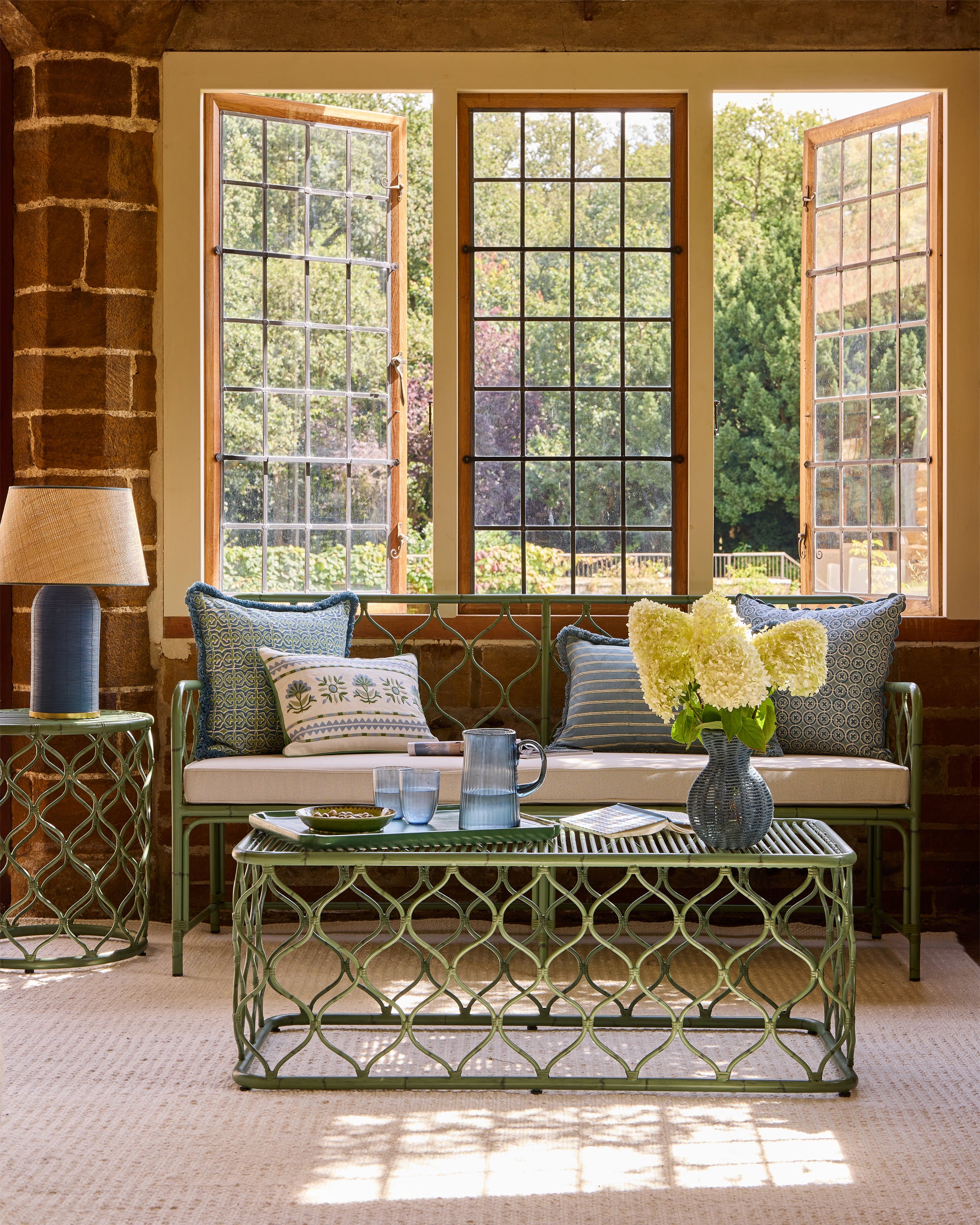 Blue and green sitting room lifestyle image, showcasing our Curato furniture and SS25 soft furnishings - Birdie Fortescue