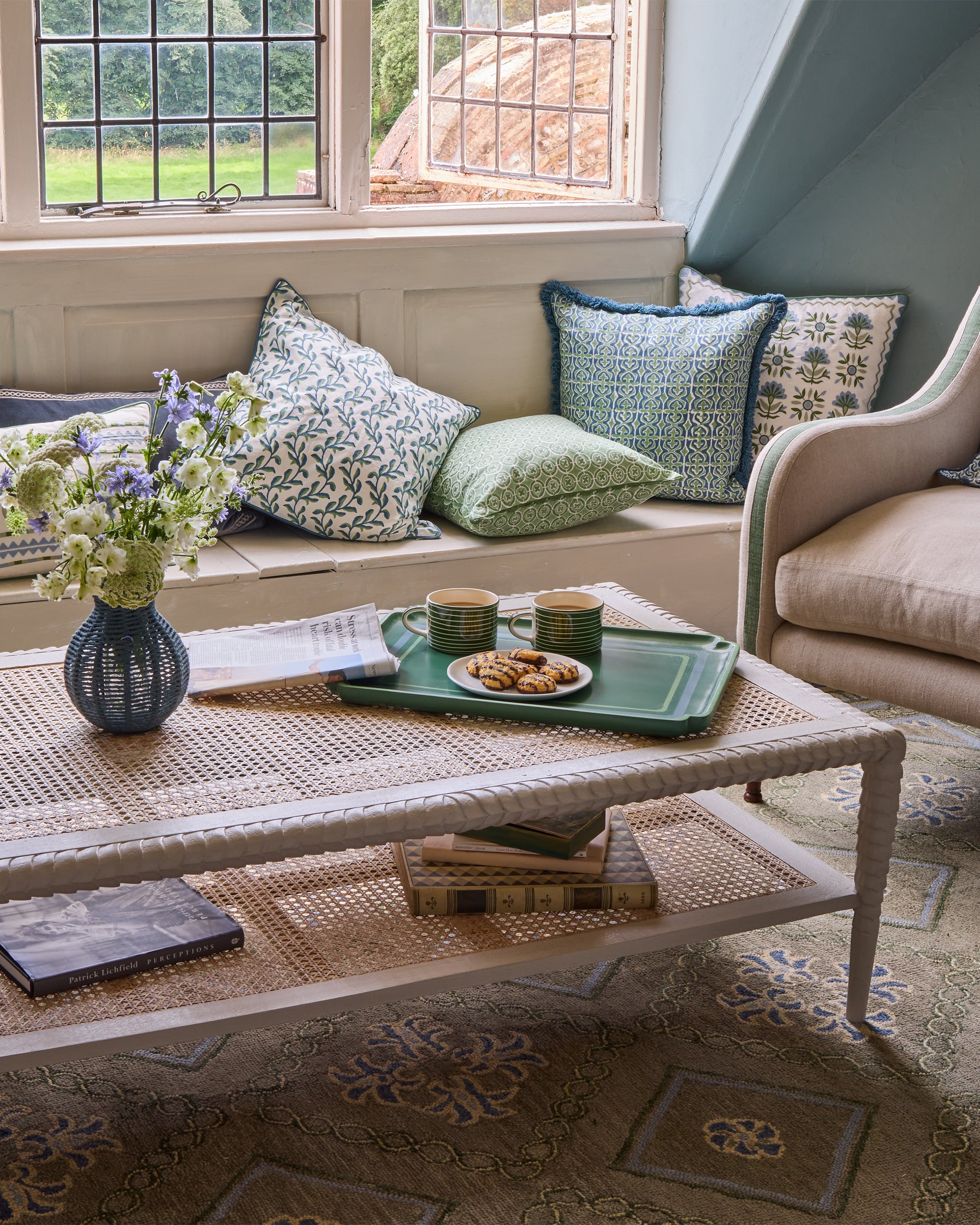 Sitting room blue and green lifestyle image, showcasing a range of our new soft furnishings and our blue string vase