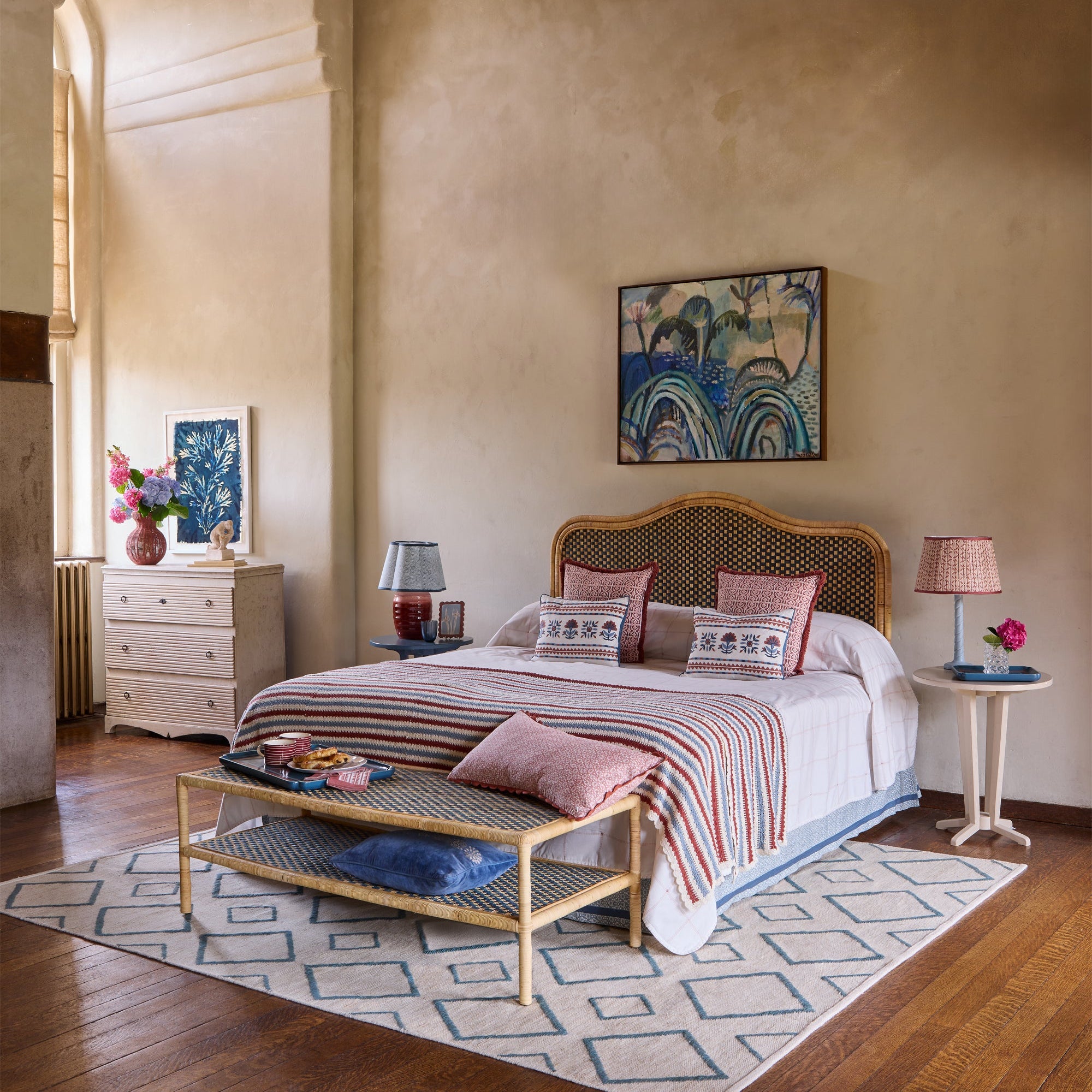 Pink and blue themed bedroom, featuring the red and blue striped crochet throw, pink margarita bolster cushion and rattan furniture