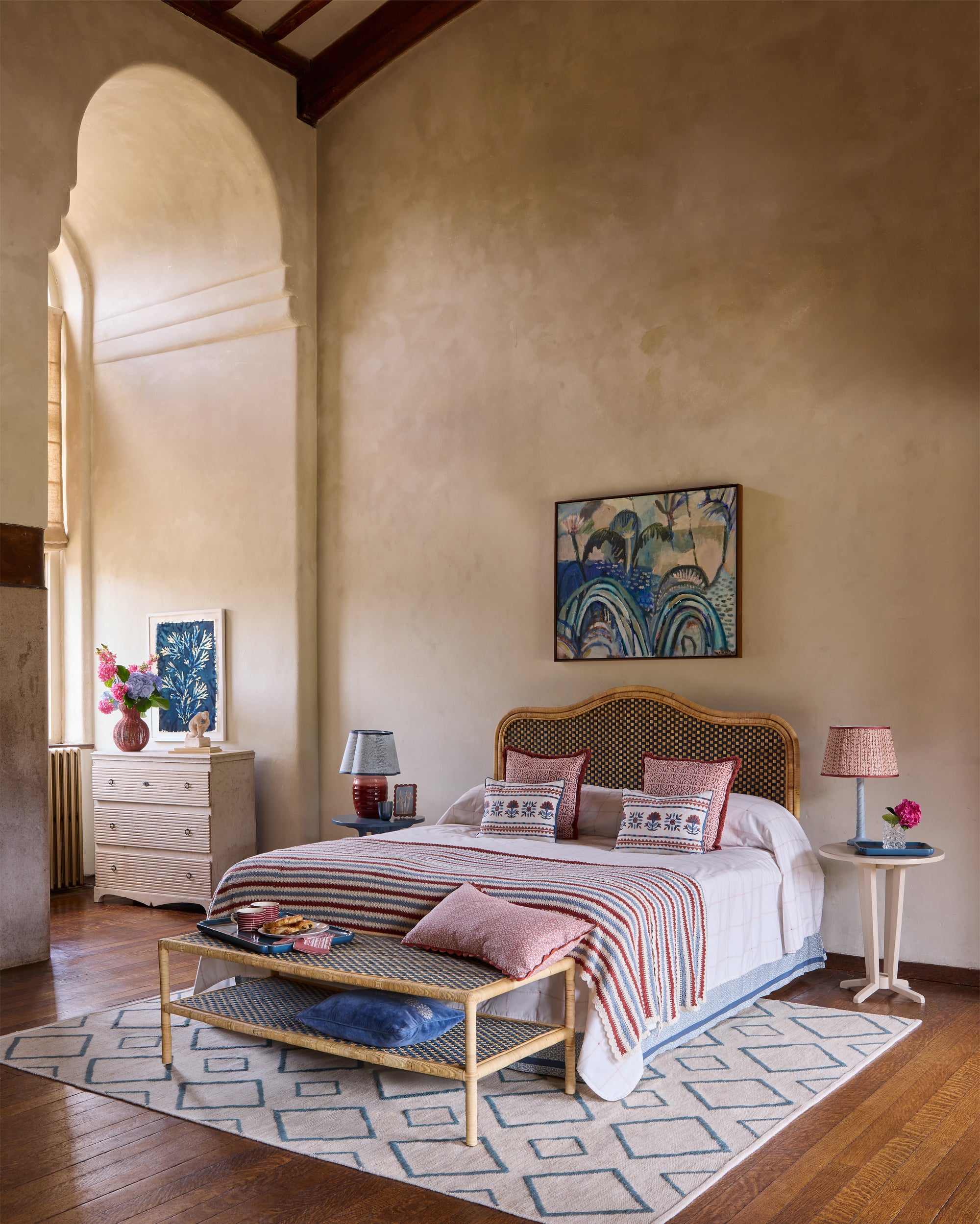 Bedroom lifestyle inspiration, featuring the blue rattan headboard, red and blue striped crochet throw and rhombus rug