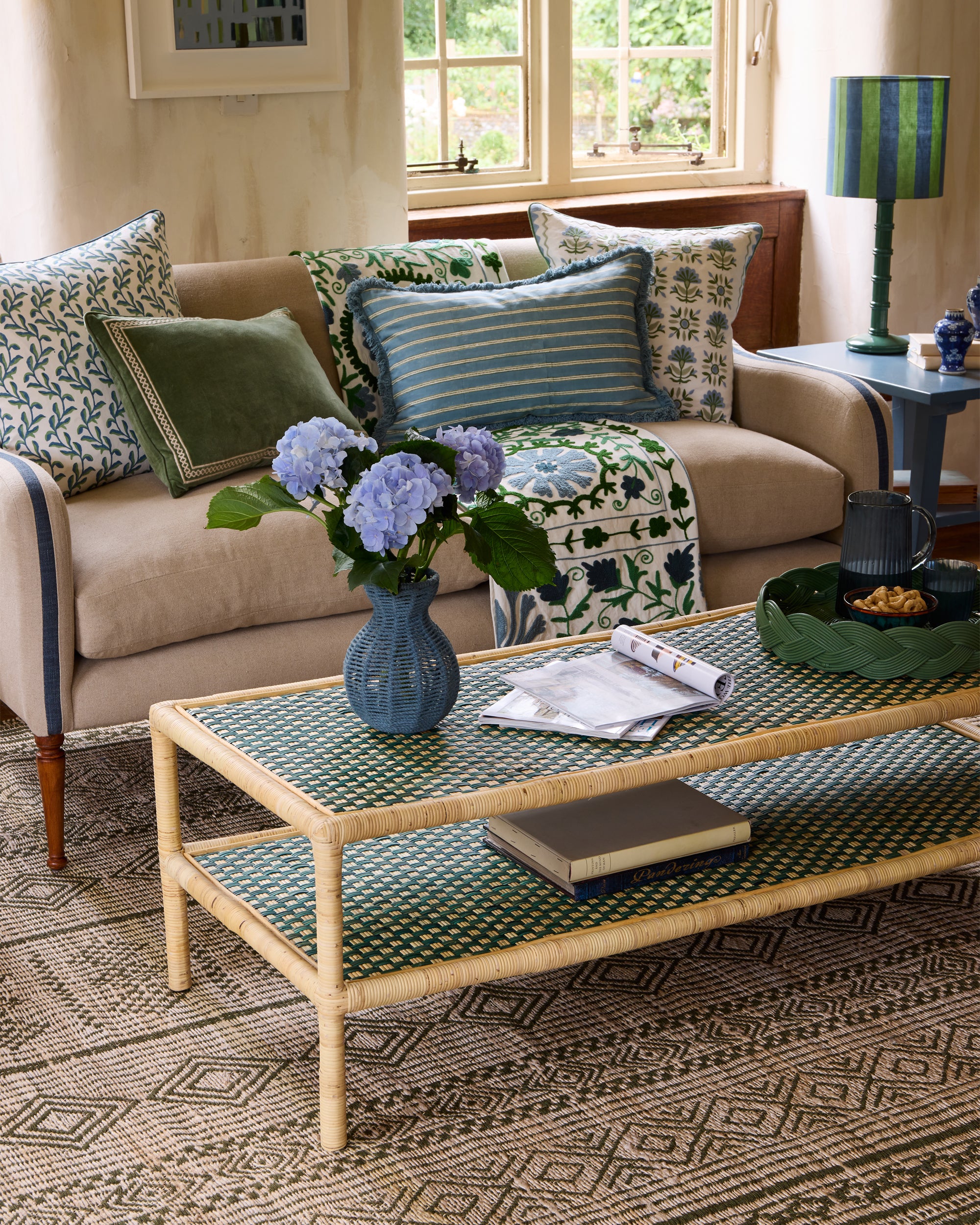 Blue and green sitting room featuring our blue string vase styled on our new Rattan Ottoman