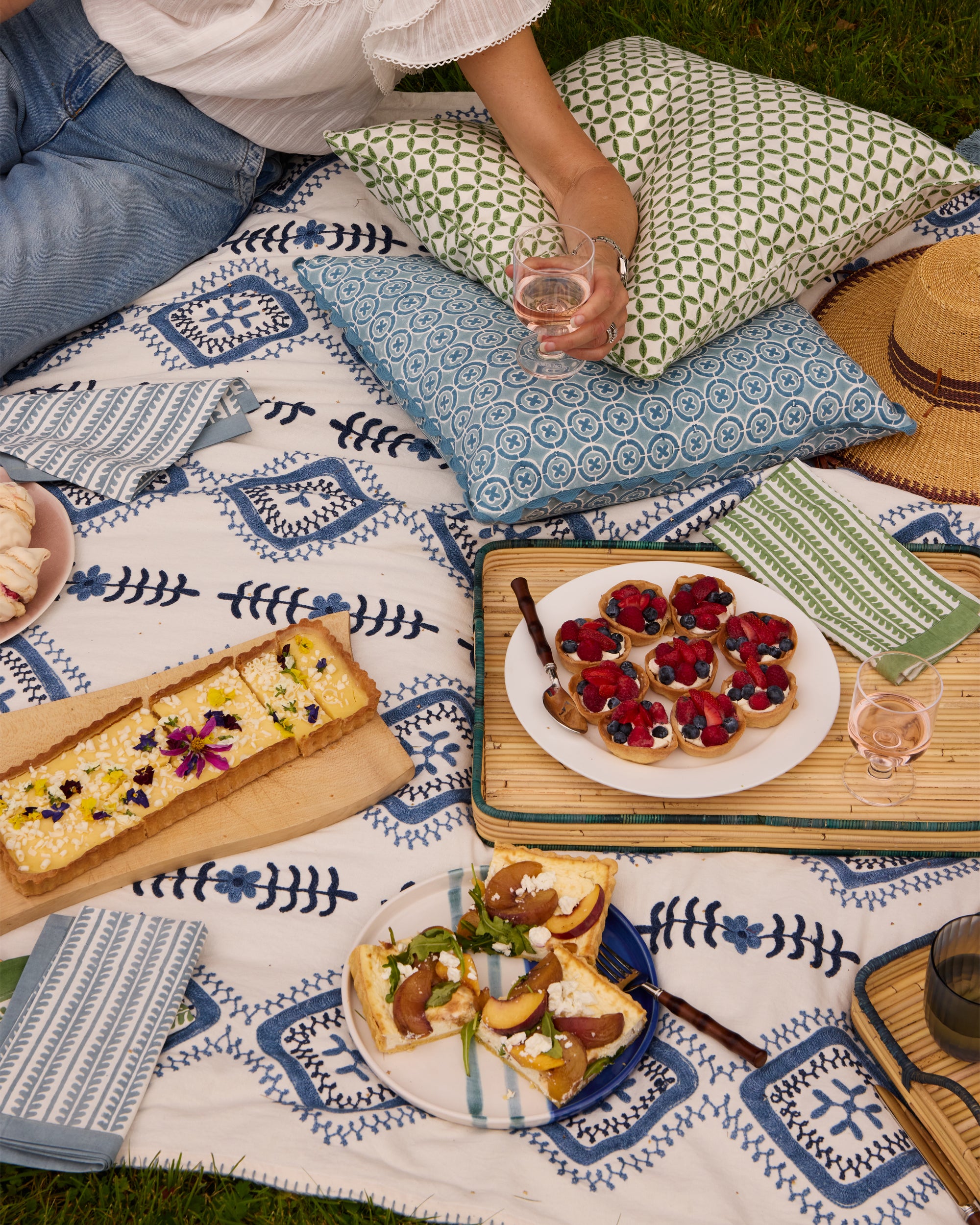 Summer picnic featuring our Amrapali Suzani in blue, Ciculo Block Print Cushio and Arriate Block Print Outdoor Cushion