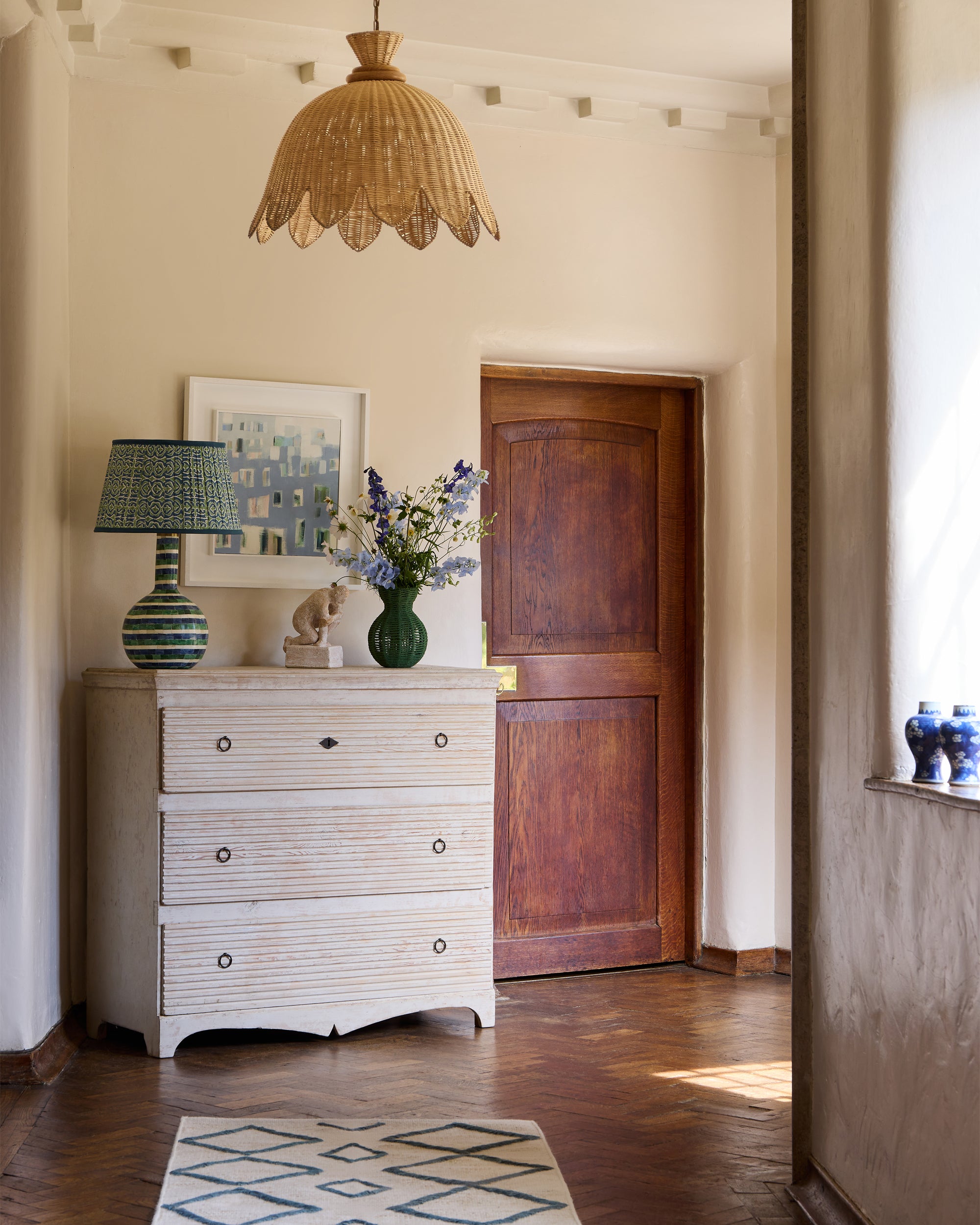 Blue and green hallway lifestyle image, featuring our green string vase styled on our white antique Chester drawers