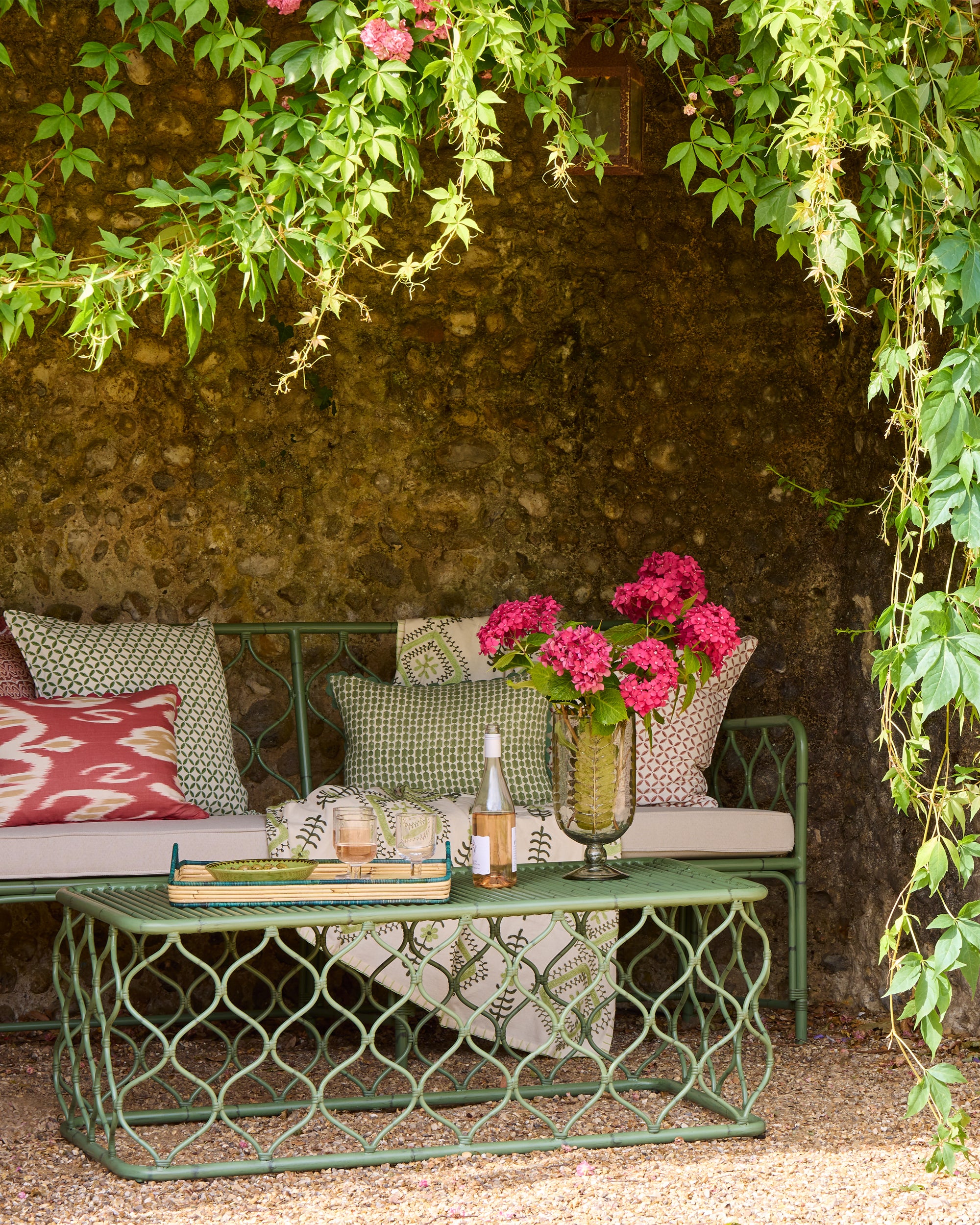 Summer outdoor garden cove lifestyle image featuring pink and green soft furnishings