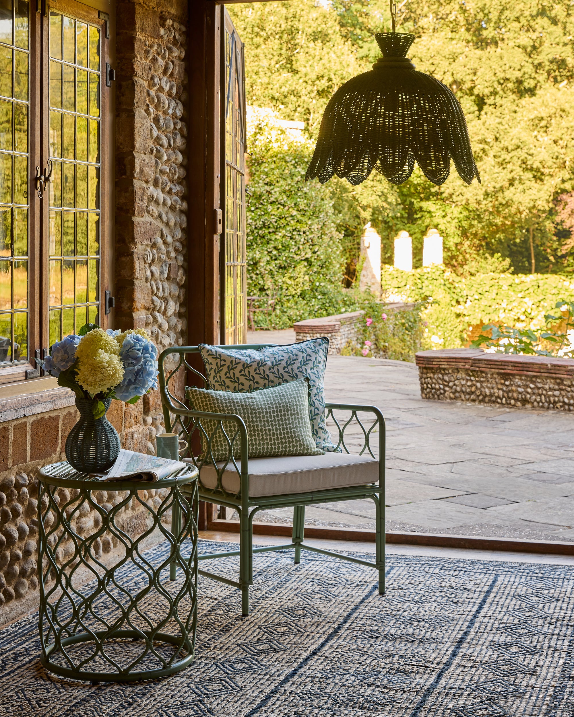 Armchair lifestyle image, featuring the curato garden side table and armchair on the blue moroccan jute rug