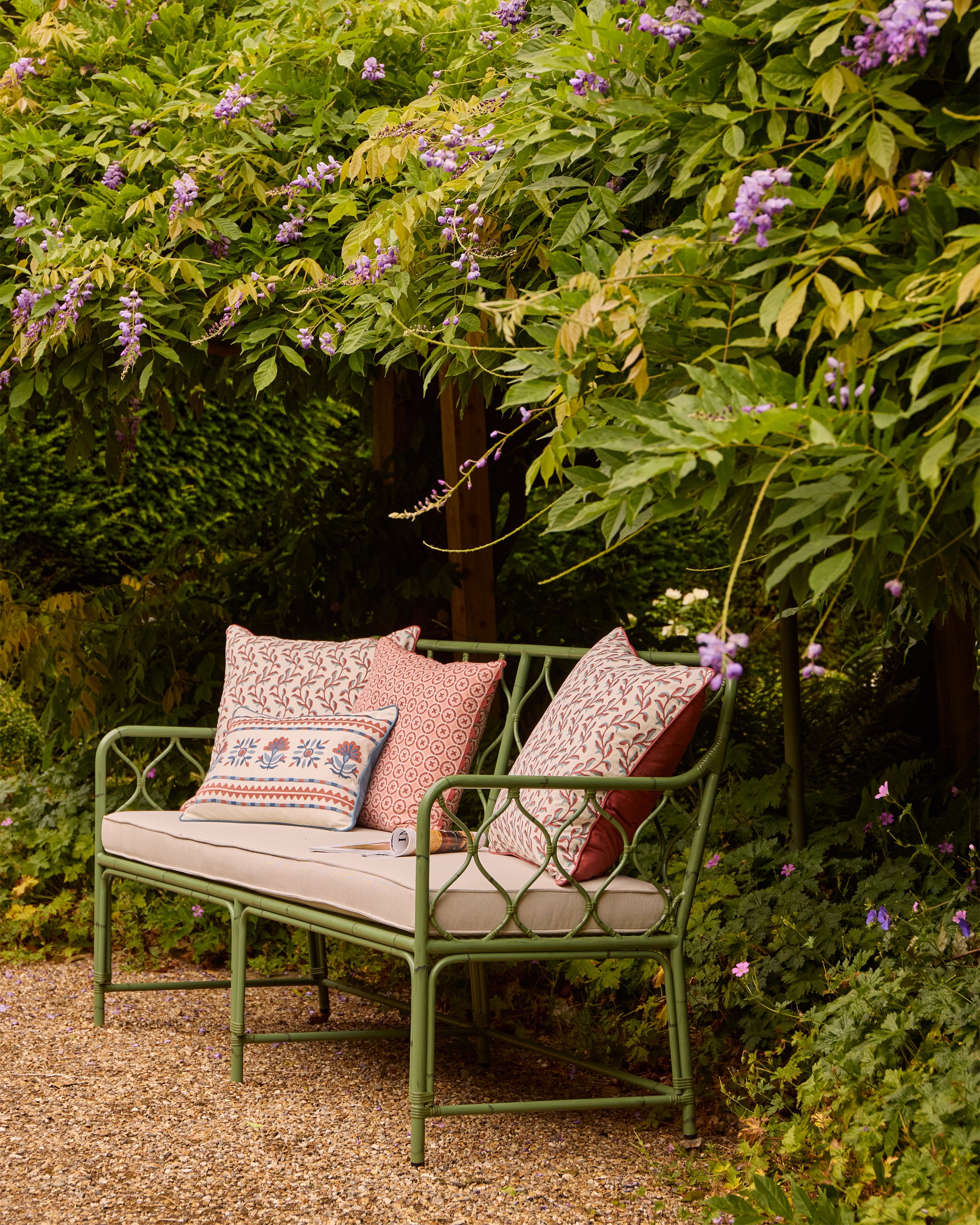 Pretty spring summer outdoor seating lifestyle image - Birdie Fortescue curato furniture and pink and blue cushions