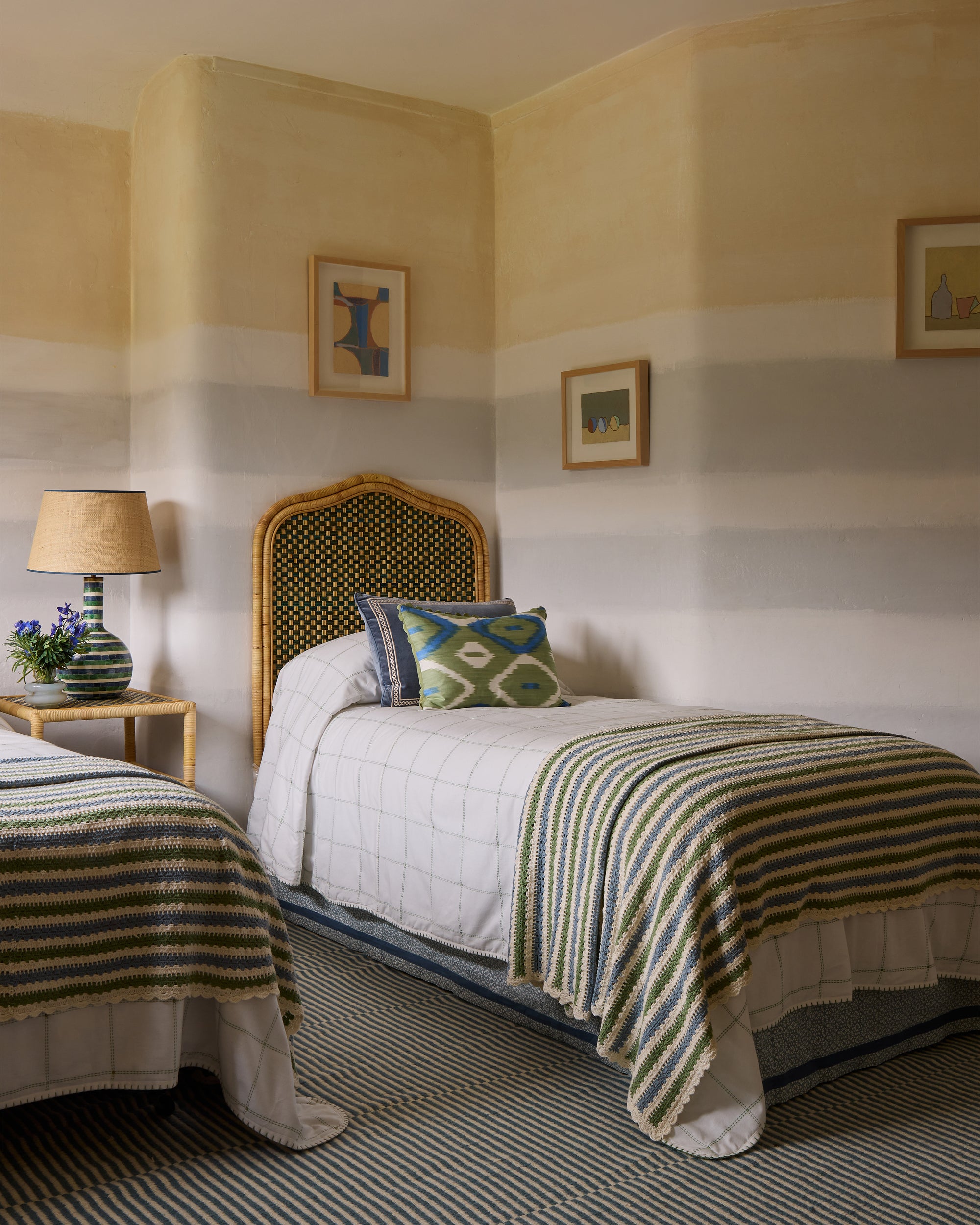 Twin single bedroom, blue and green themed featuring, the rattan headboard, quilted bedspread and striped crochet throw