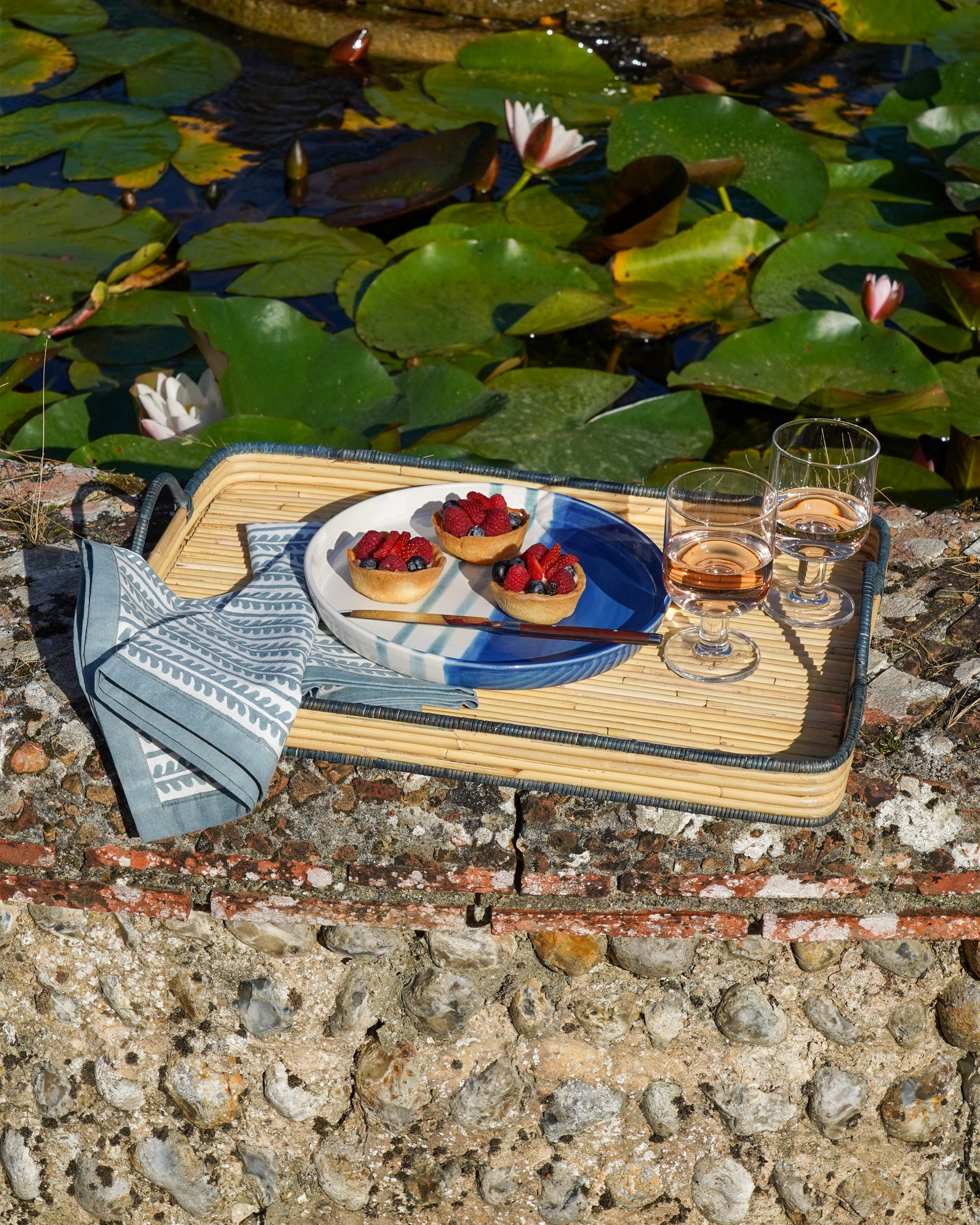 Summer handwoven rattan tray beside the pond - Birdie Fortescue