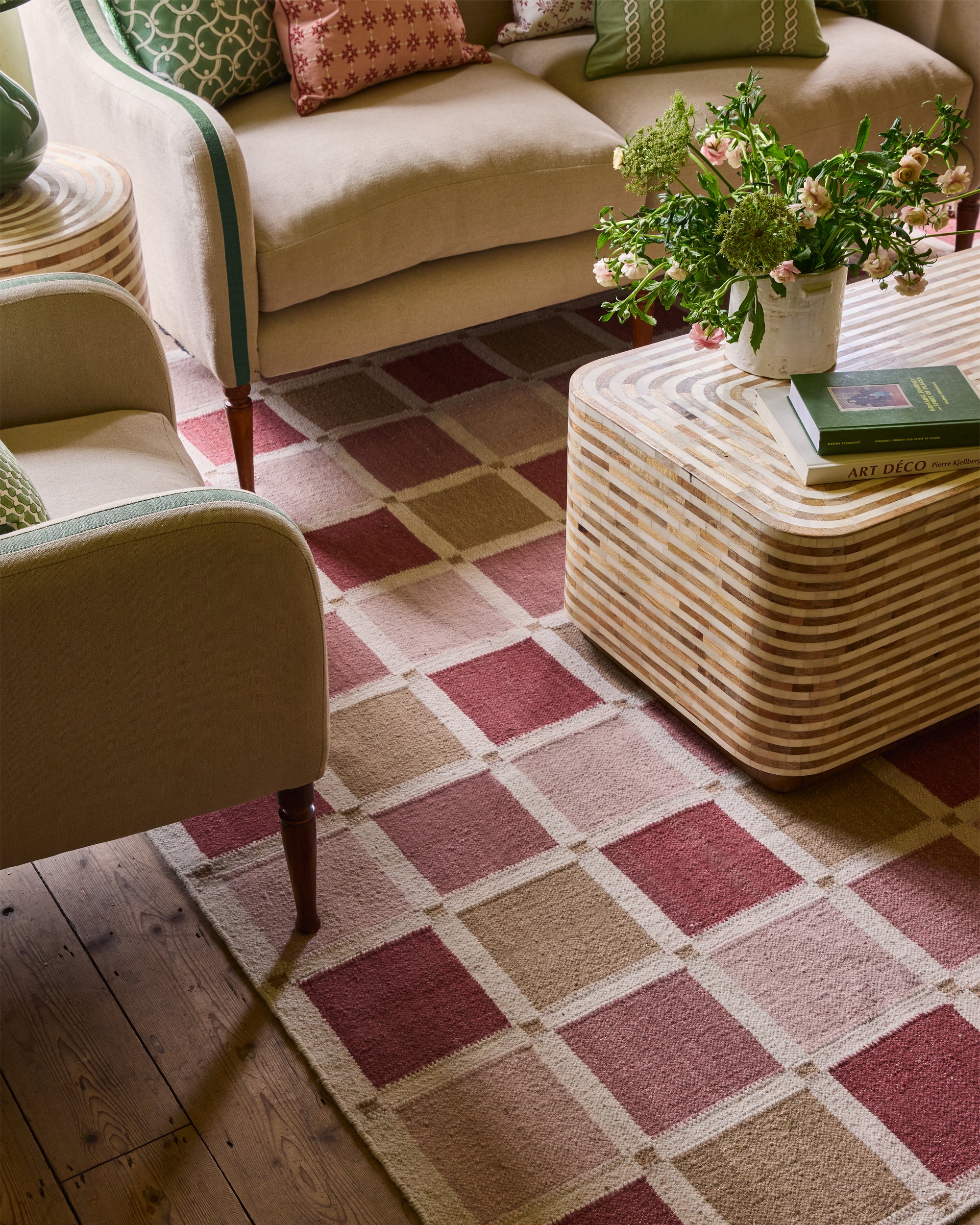 Living room with a checkered rug, beige sofa, and wicker coffee table.