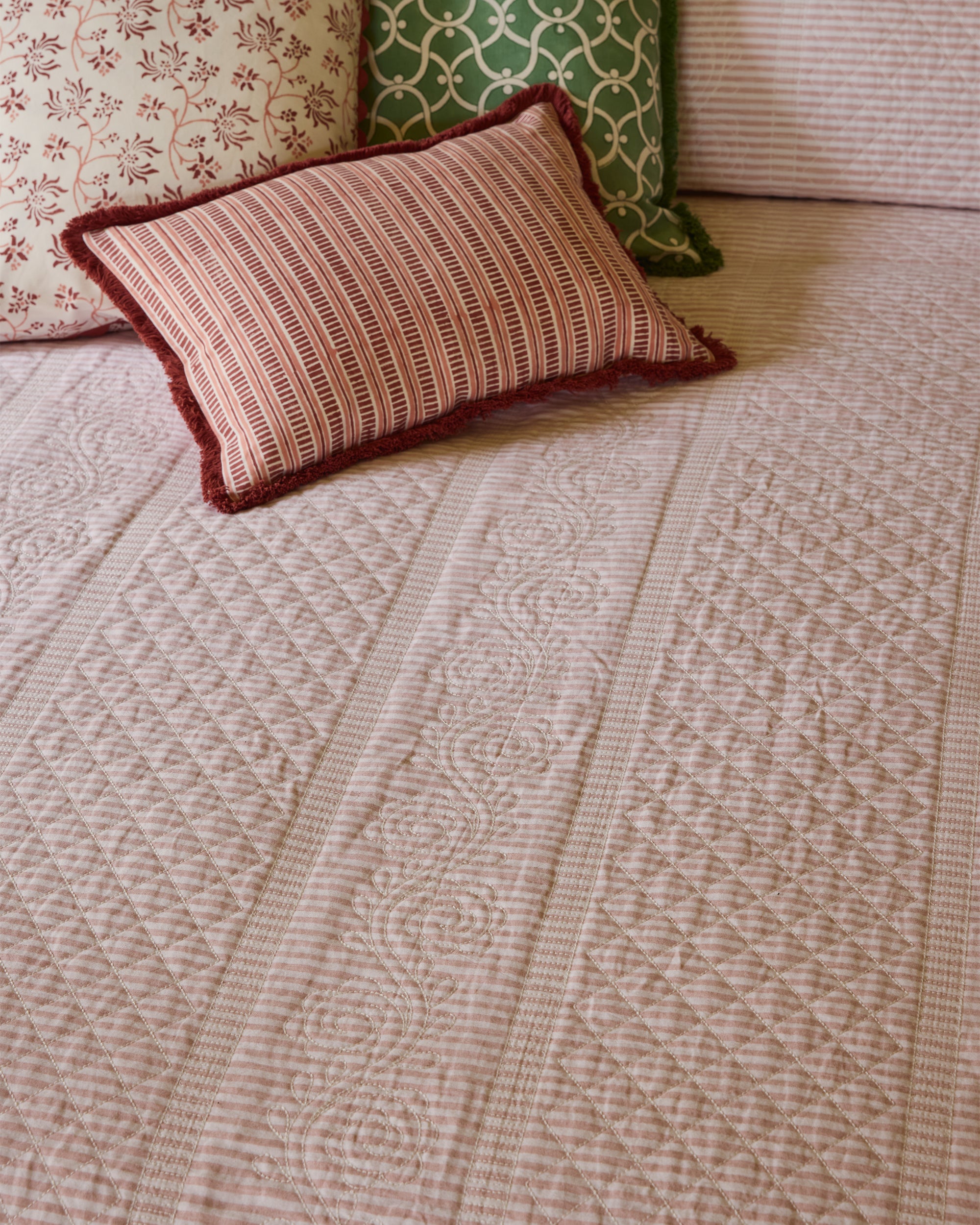 Patterned bedspread with a decorative pillow on a bed