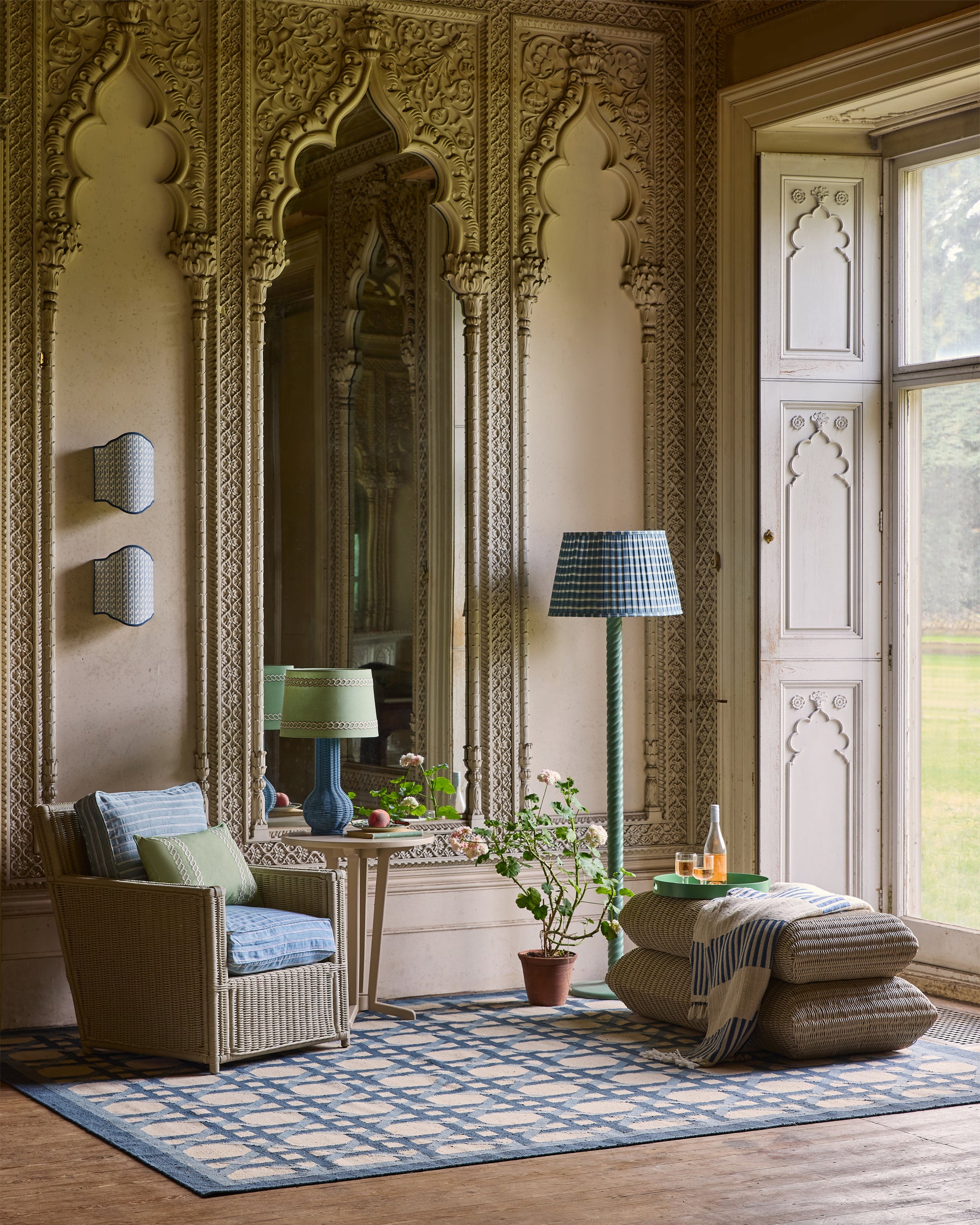 Decorative living room with ornate wall designs, a chair, and a lamp.