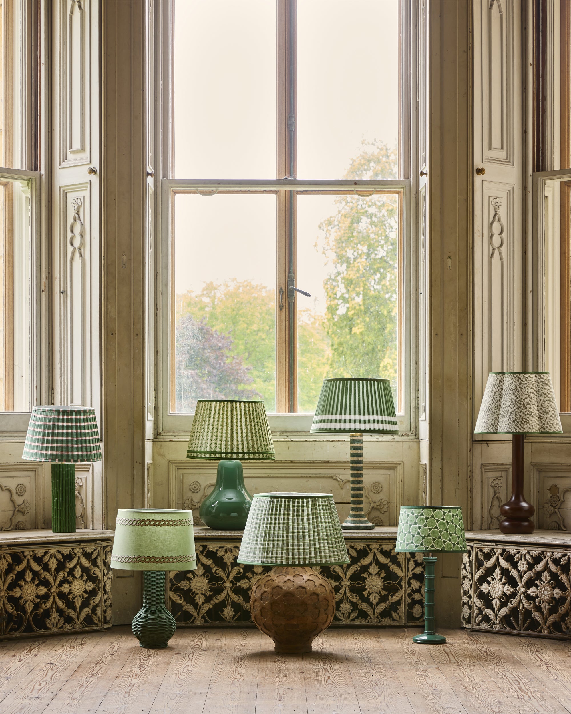 Decorative lamps with green and white checkered lampshades in a room with large windows.