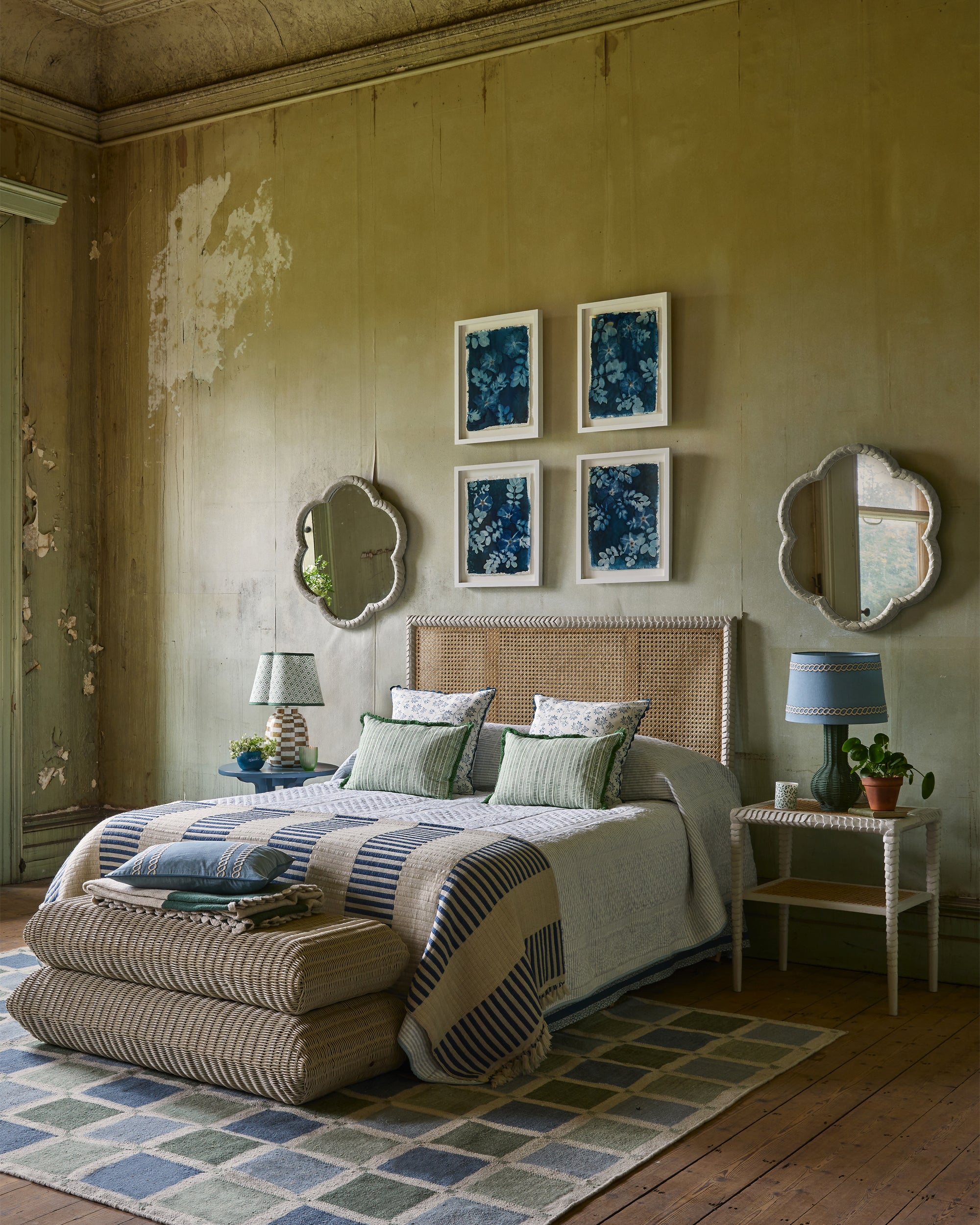 Cozy bedroom with wicker bed, framed blue artworks, and decorative mirrors.
