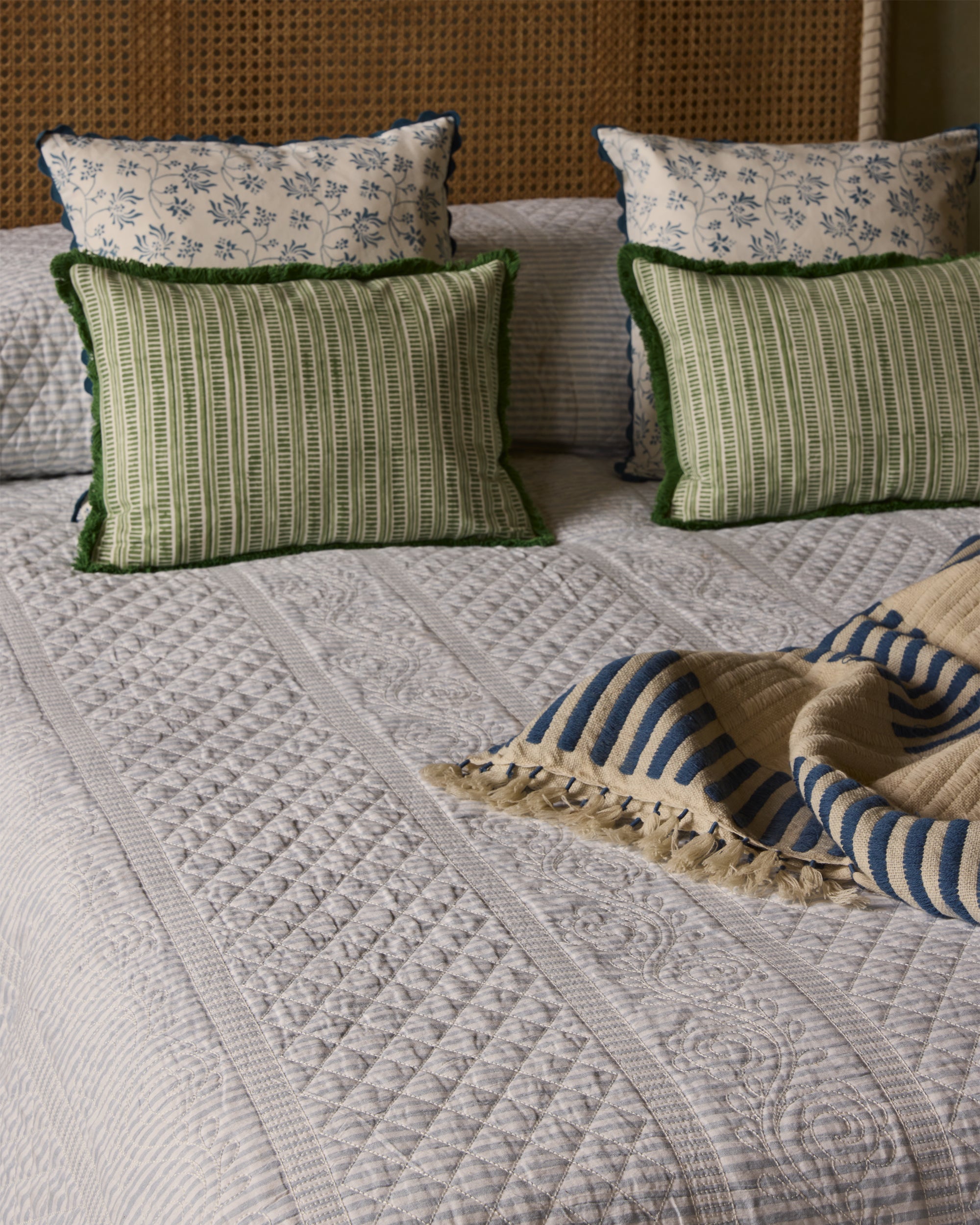 Bed with patterned bedding, pillows, and a blanket