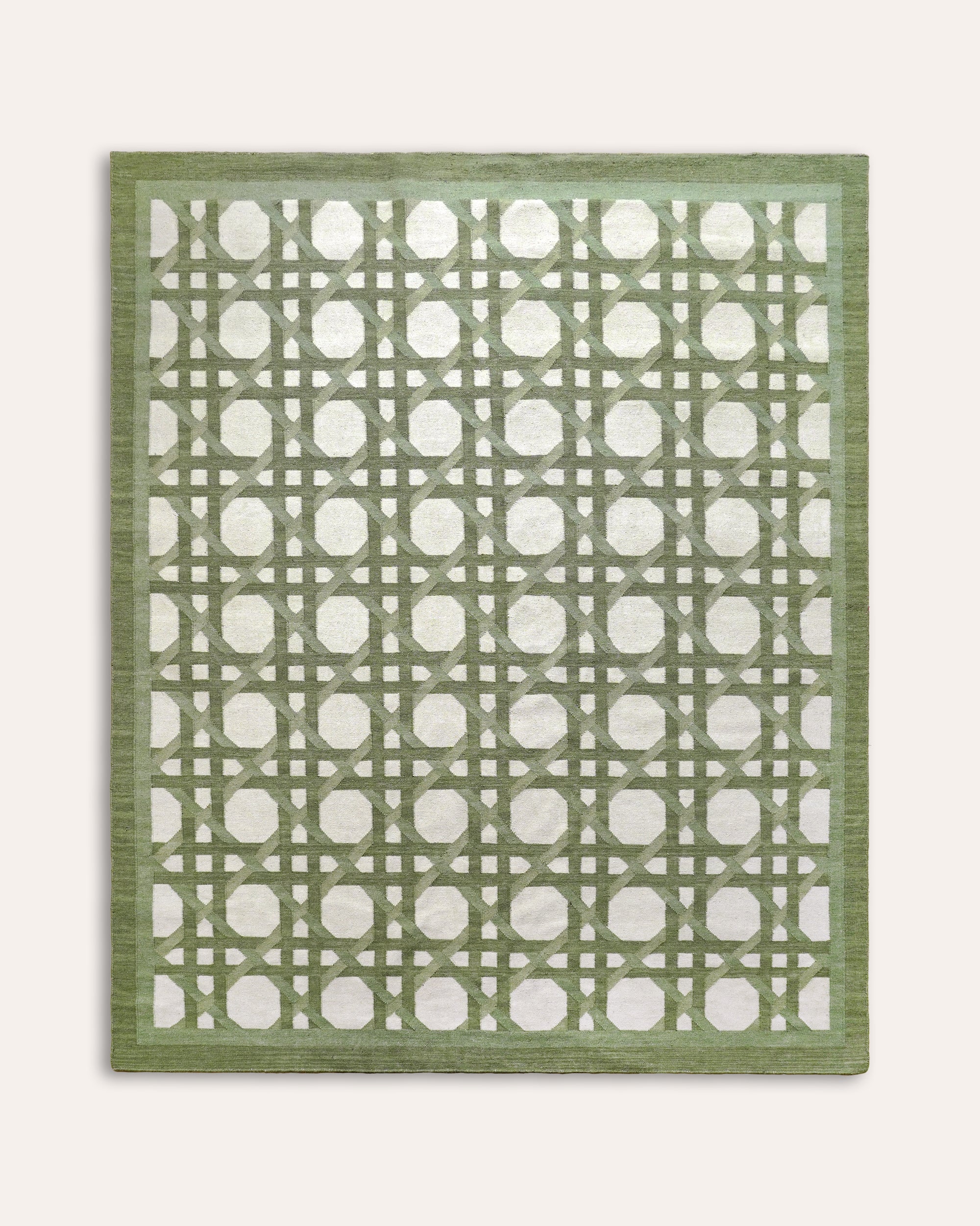 Green Ganna flat weave rug with a geometric pattern and striped border on a taupe background